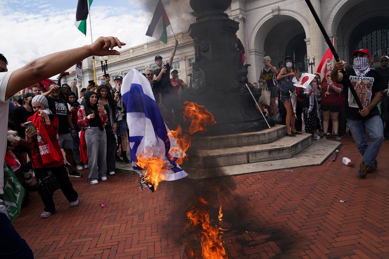 Pro-Palestinian demonstrators burn an Israeli flag, on the day of Israeli Prime Minister Benjamin Netanyahu's address to a joint meeting of Congress, on Capitol Hill in Washington, U.S., July 24, 2024. REUTERS