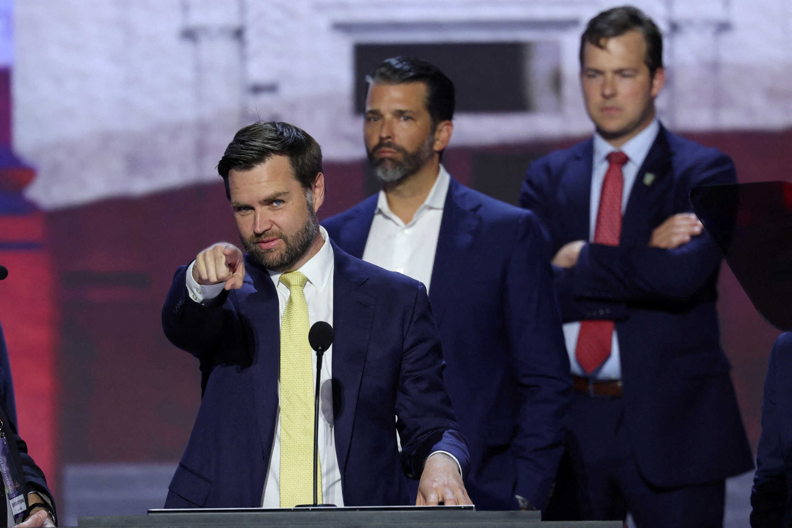 Republican vice presidential nominee J.D. Vance gestures as he is joined onstage by Donald Trump Jr. during his walk-thru ahead of Day 2 of the Republican National Convention (RNC), at the Fiserv Forum in Milwaukee, Wisconsin, U.S., July 16, 2024. REUTERS