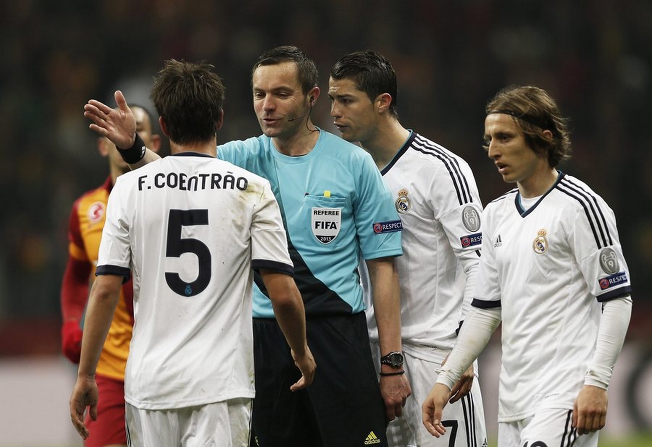 epa03655745 Real Madrid players Fabio Coentrao (L), Cristiano Ronaldo (2nd R) and Luka Modric (R) argue with French referee Stephane Lannoy (2nd L) during the UEFA Champions League quarter final second leg soccer match between Galatasaray and Real Madrid in Istanbul, Turkey, 09 April 2013.  EPA