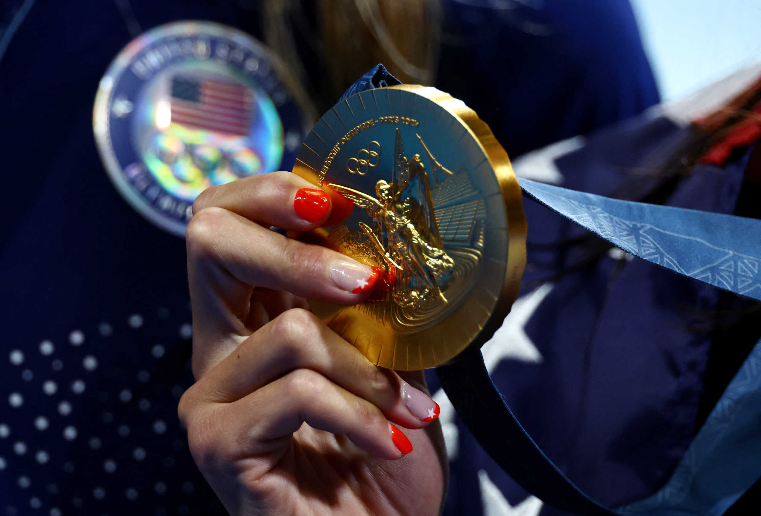Paris 2024 Olympics - Swimming - Women's 100m Butterfly Victory Ceremony - Paris La Defense Arena, Nanterre, France - July 28, 2024. Gold medallist Torri Huske of United States holds her medal as she celebrates winning. REUTERS