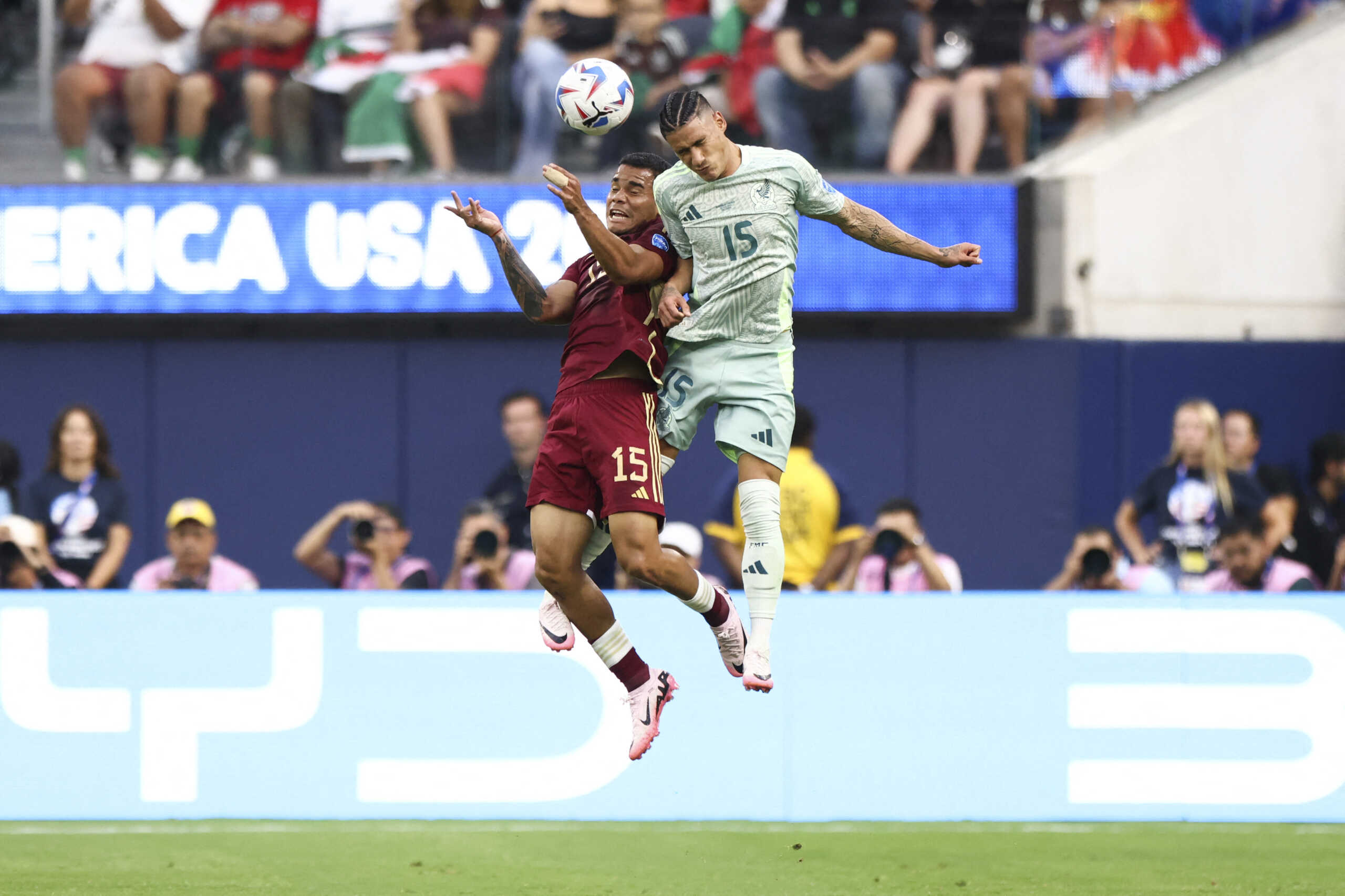 Jun 26, 2024; Inglewood, CA, USA; Venezuela defender Miguel Ángel Navarro (15) and Mexico midfielder Uriel Antuna (15) battle for a header during the first half of a match at SoFi Stadium. Mandatory Credit: Jessica Alcheh-USA TODAY Sports