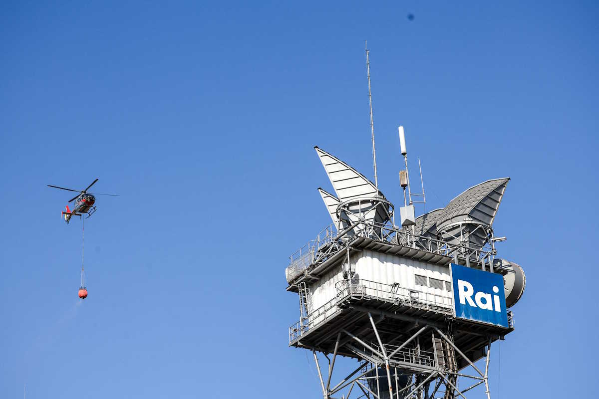 A helicopter prepares to drop water near the headquarters of Italian state broadcaster RAI to extinguish a fire that broke out on the slopes of the Monte Mario hill in Rome, Italy, July 31, 2024 REUTERS