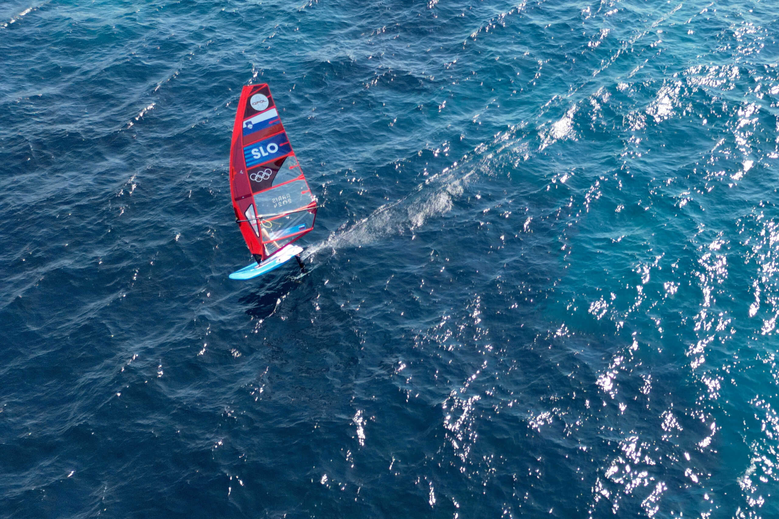 Paris 2024 Olympics - Marseille, France - July 27, 2024. This aerial photograph shows an athlete from Slovenia sailing on an iQFoil during a training session in the bay of Marseille, southern France, on the eve of the beginning of the sailing events of the Paris 2024 Olympic Games.   NICOLAS TUCAT