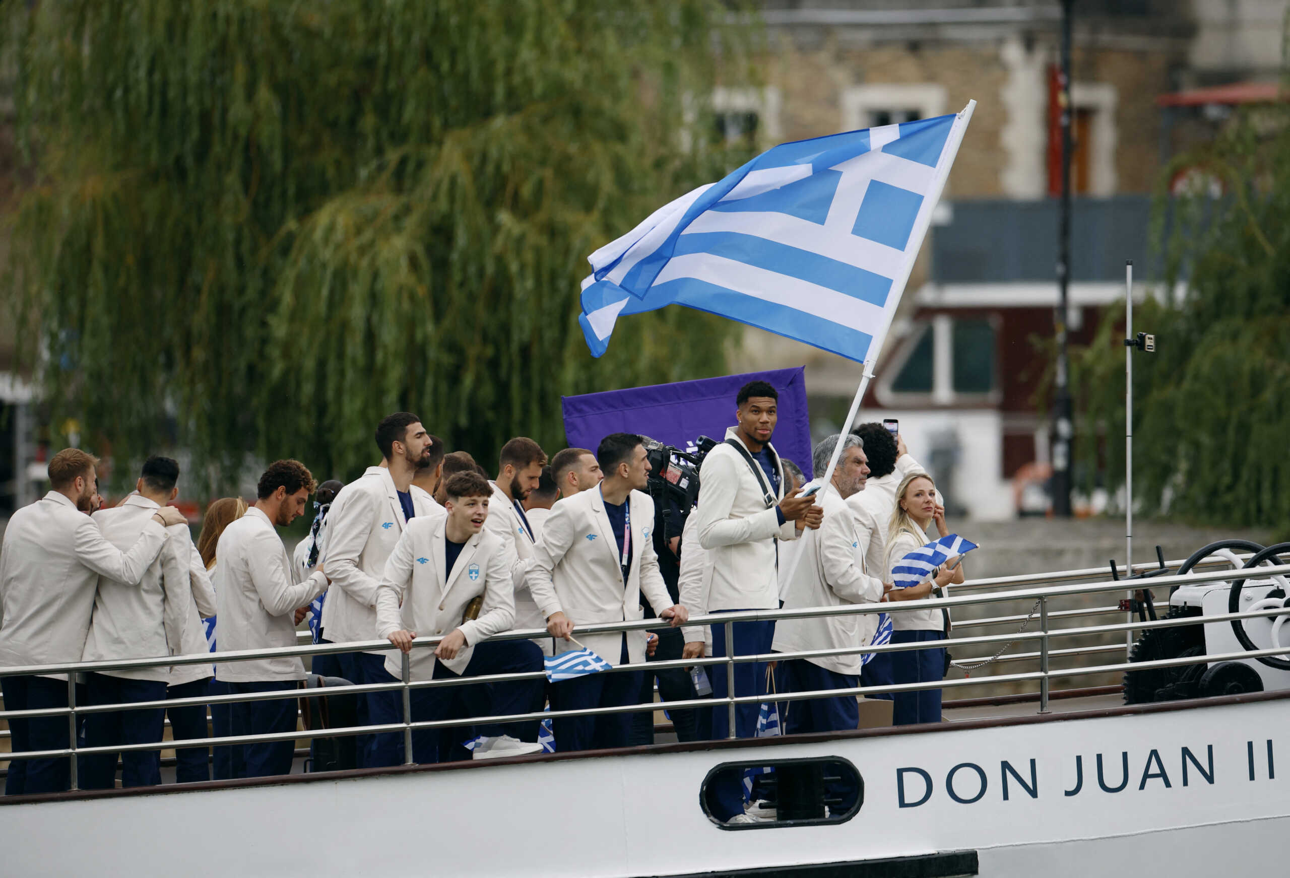 Paris 2024 Olympics - Opening Ceremony - Paris, France - July 26, 2024. Giannis Antetokounmpo of Greece and athletes are seen aboard a boat in the floating parade on the river Seine during the opening ceremony. REUTERS