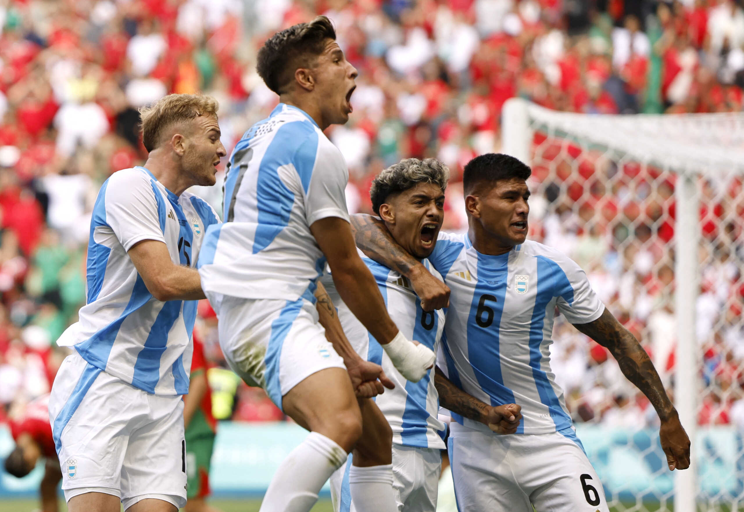 Paris 2024 Olympics - Football - Men's Group B - Argentina vs Morocco - Geoffroy-Guichard Stadium, Saint-Etienne, France - July 24, 2024. Cristian Medina of Argentina celebrates scoring their second goal with teammates. REUTERS