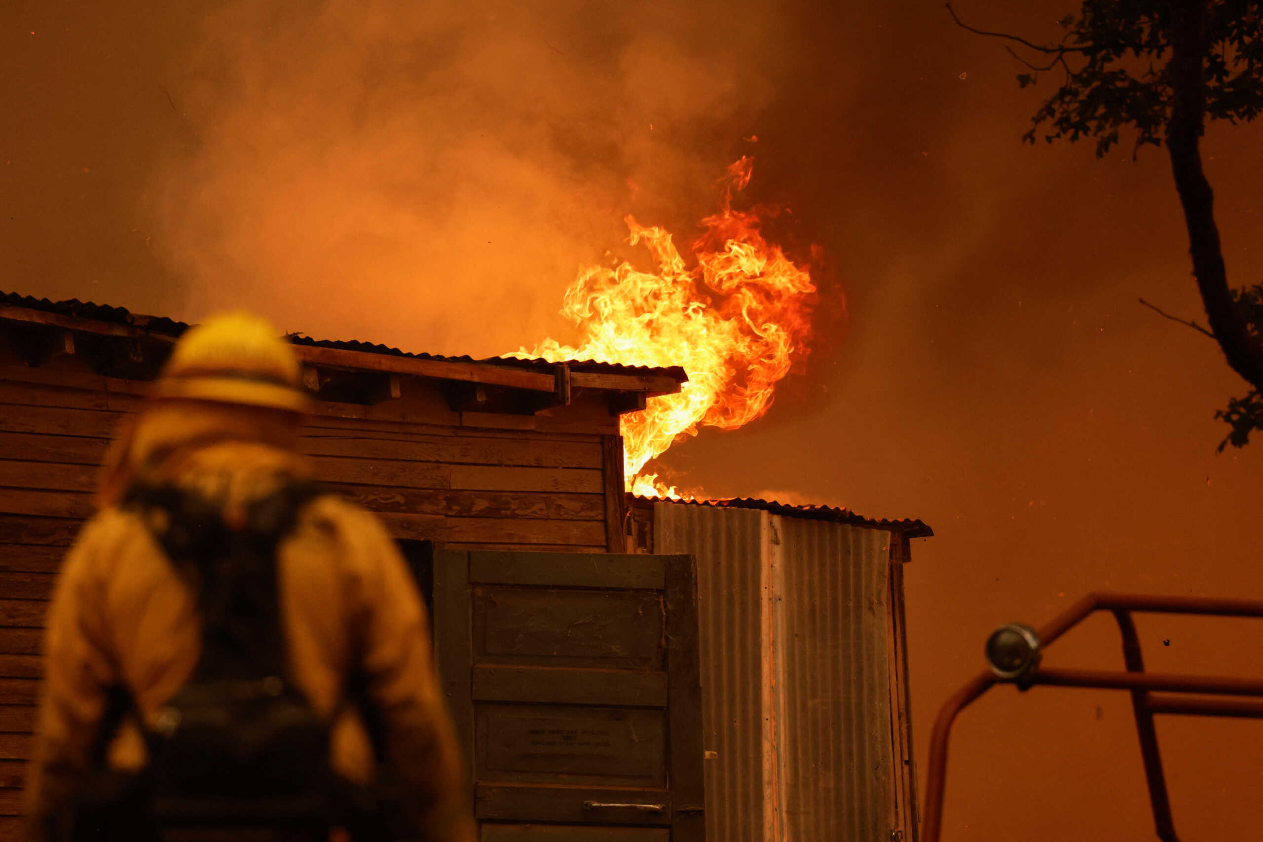 A firefighter works to save a burning structure amid the Park Fire in the community of Cohasset near Chico, California, U.S. July 25, 2024.  REUTERS