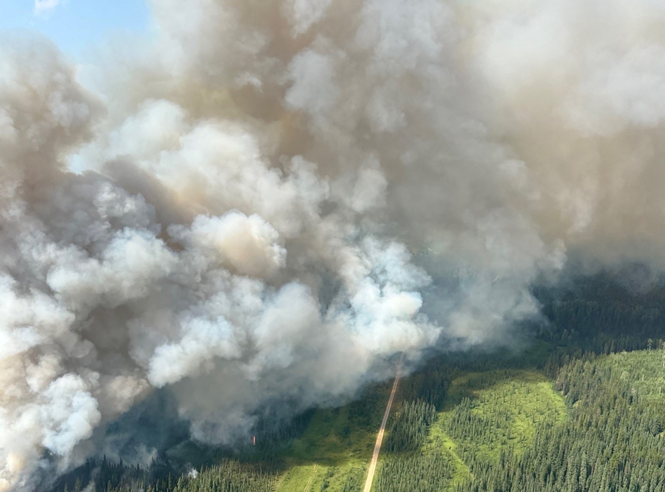 Smoke rises from the CWF057 wildfire west of Water Valley, Alberta, Canada in a photograph released July 24, 2024.   Alberta Wildfire