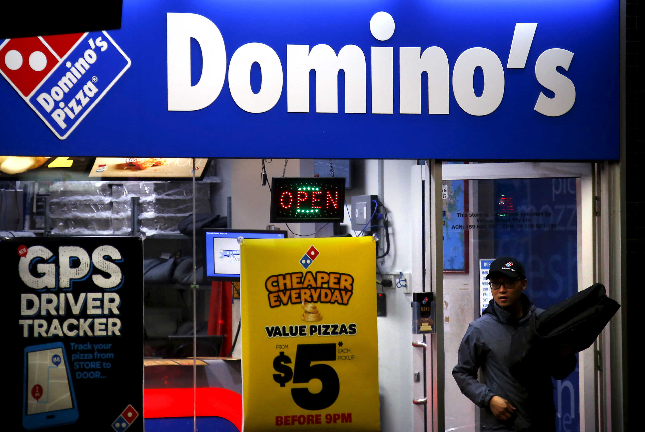 FILE PHOTO: A worker carries a pizza for delivery as he exits a Domino's pizza store in Sydney, Australia, August 12, 2015. REUTERS