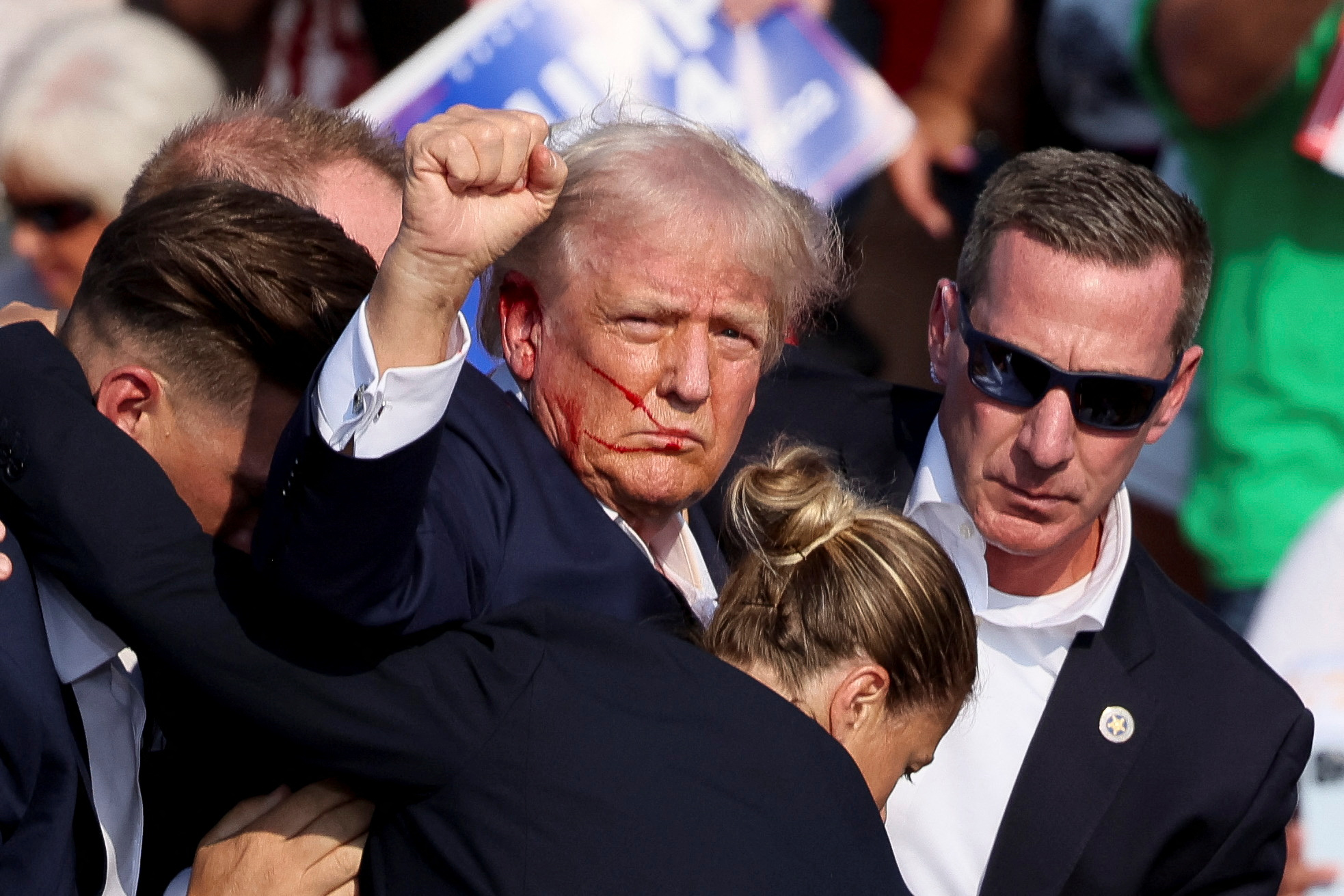 Republican presidential candidate and former U.S. President Donald Trump gestures as he is assisted by U.S. Secret Service after gunfire rang out during a campaign rally at the Butler Farm Show in Butler, Pennsylvania, U.S., July 13, 2024. REUTERS