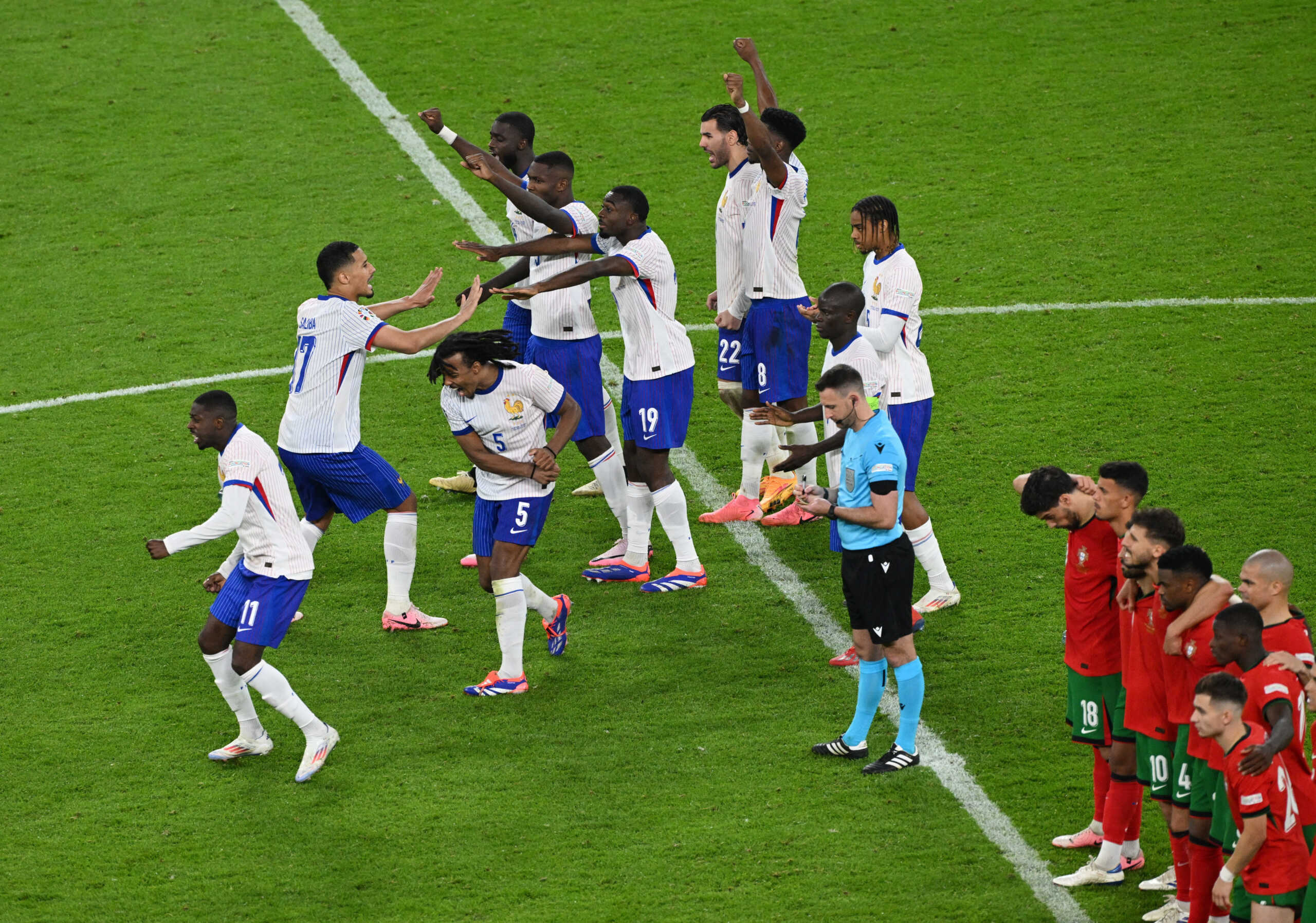 Soccer Football - Euro 2024 - Quarter Final - Portugal v France - Hamburg Volksparkstadion, Hamburg, Germany - July 5, 2024 France players celebrate in the centre circle after Portugal's Joao Felix missed a penalty in the penalty shootout REUTERS