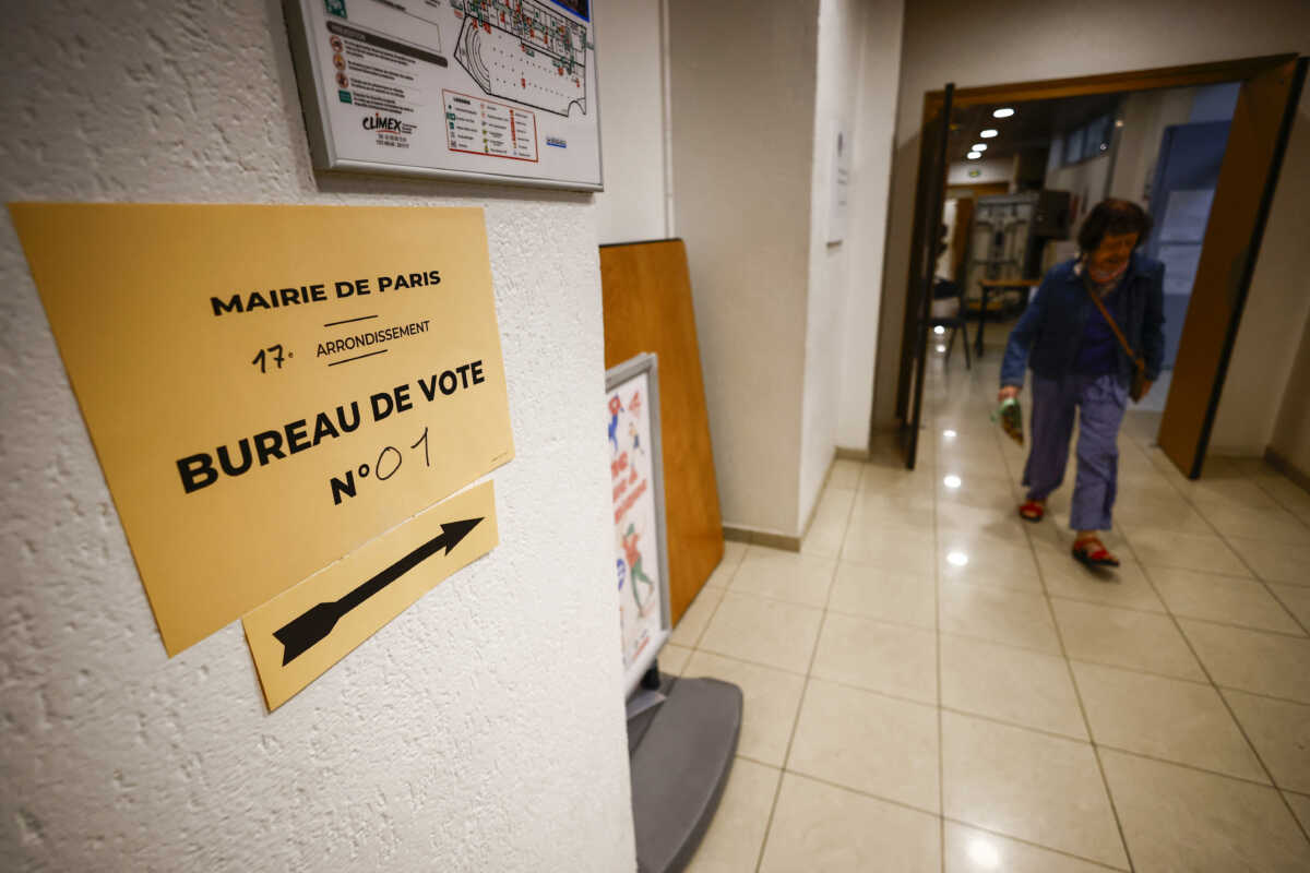 A woman leaves a polling station after voting in the second round of the early French parliamentary elections, in Paris, France, July 7, 2024. REUTERS