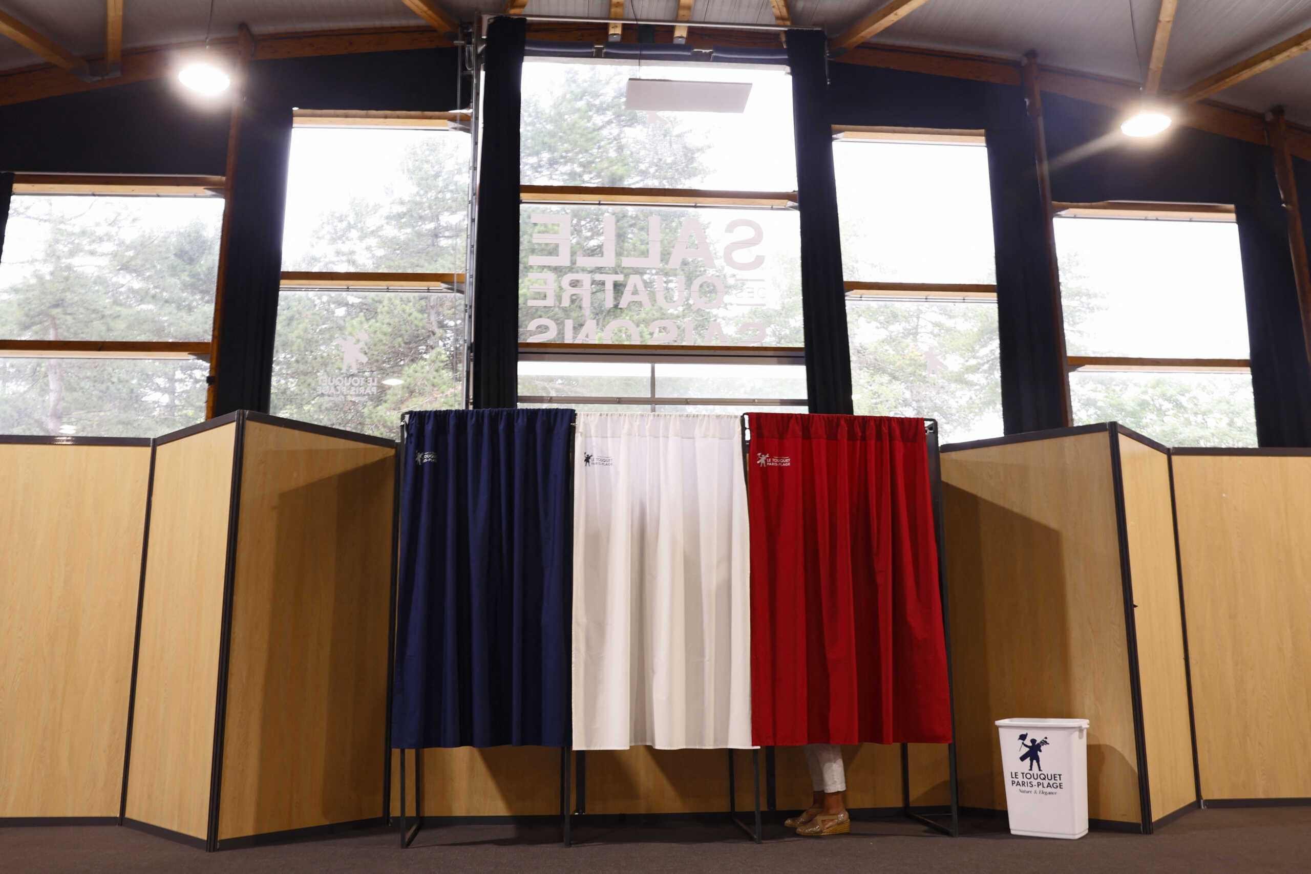 A voter stands in a polling booth to vote in the second round of the early French parliamentary elections, at a polling station in Le Touquet-Paris-Plage, France, July 7, 2024. REUTERS
