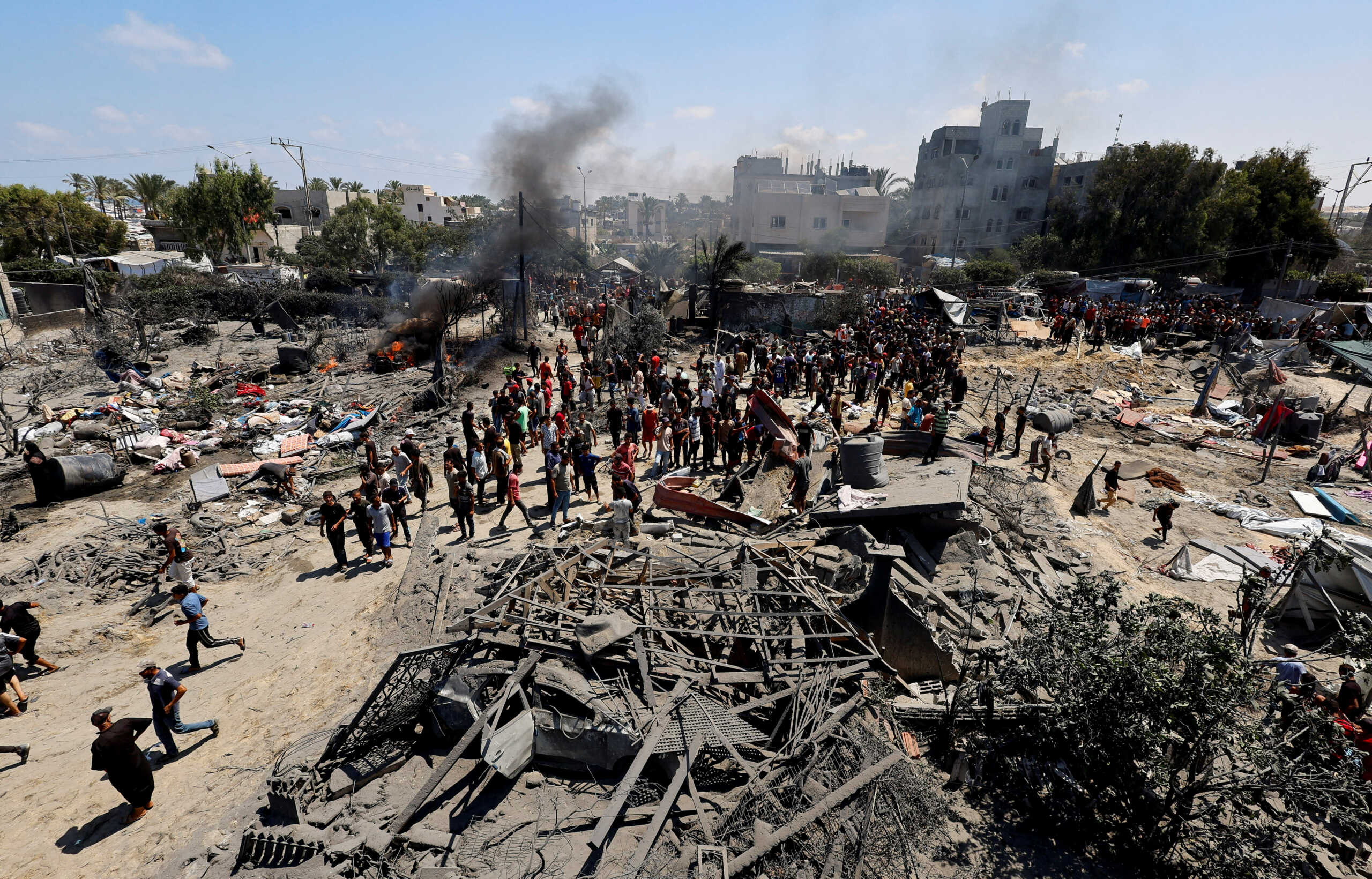 Palestinians gather near damage, following what Palestinians say was an Israeli strike at a tent camp in Al-Mawasi area, amid Israel-Hamas conflict, in Khan Younis in the southern Gaza Strip July 13, 2024. REUTERS