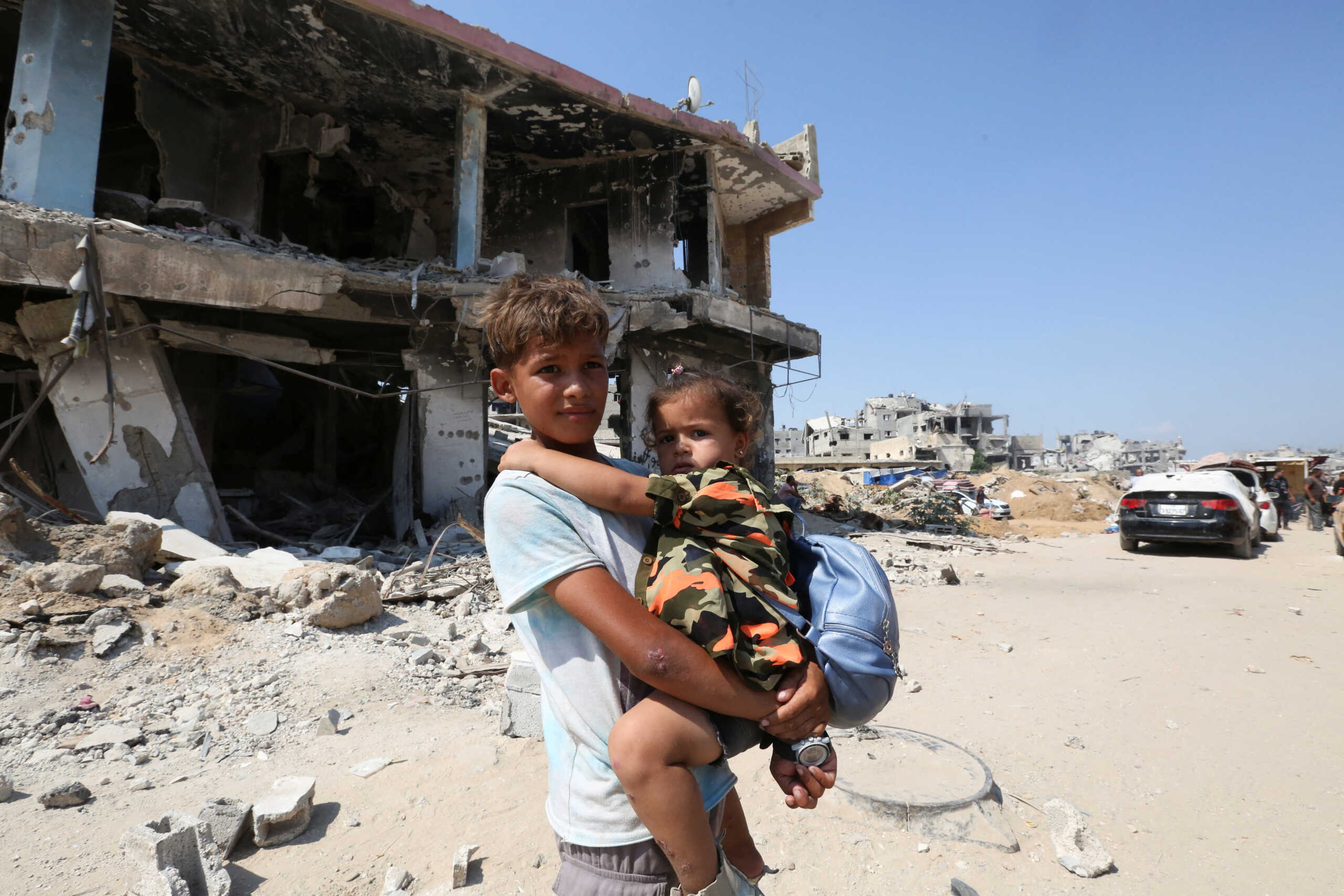 A Palestinian boy holds a girl as they flee the eastern part of Khan Younis to make their way after they were ordered by Israeli army to evacuate their neighborhoods, amid Israel-Hamas conflict, in Khan Younis in the southern Gaza Strip July 22, 2024. REUTERS