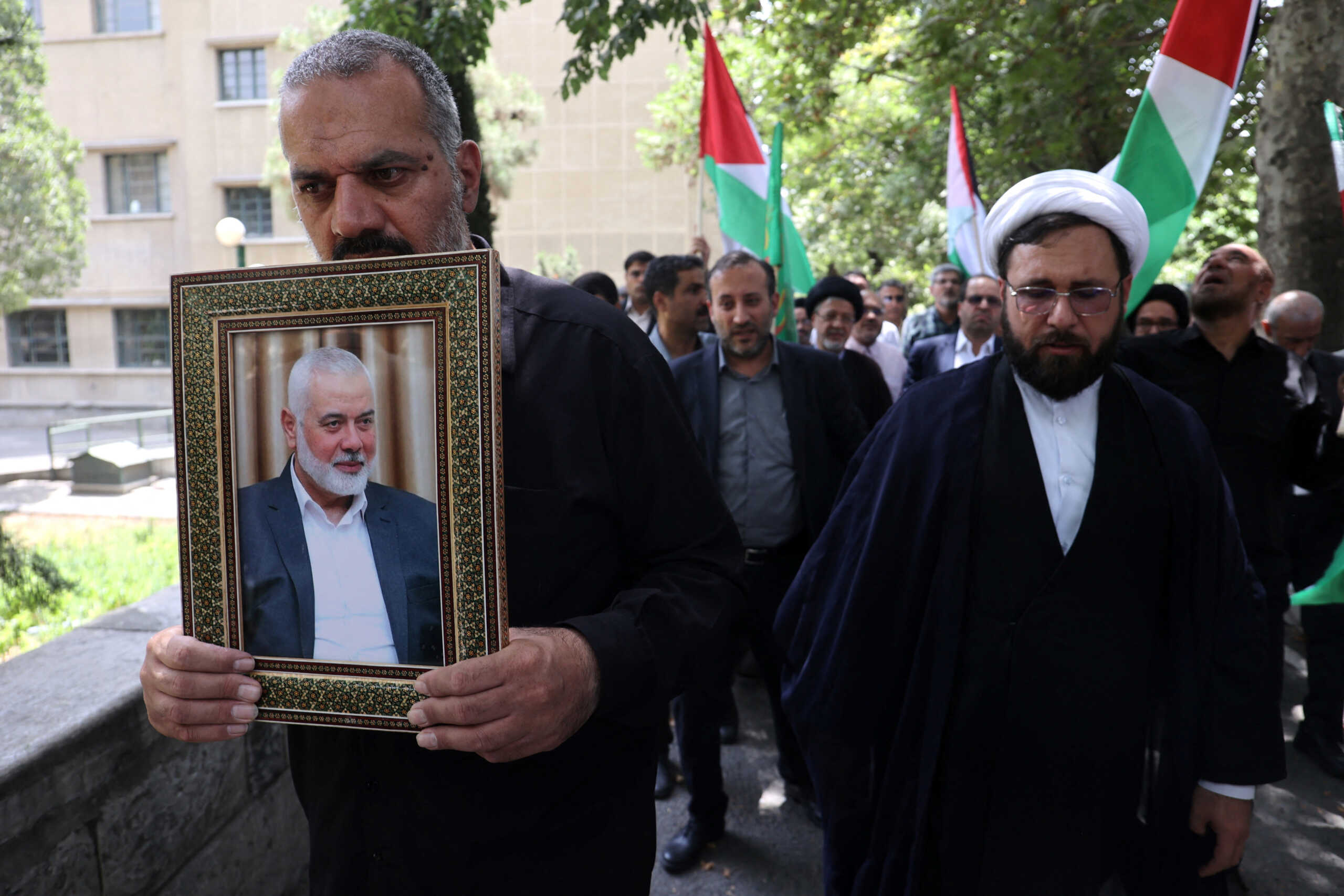 An Iranian man holds a picture of Palestinian group Hamas' top leader Ismail Haniyeh, following the killing of him, amid the ongoing conflict between Israel and Hamas, in Tehran, Iran July 31, 2024. Majid Asgaripour
