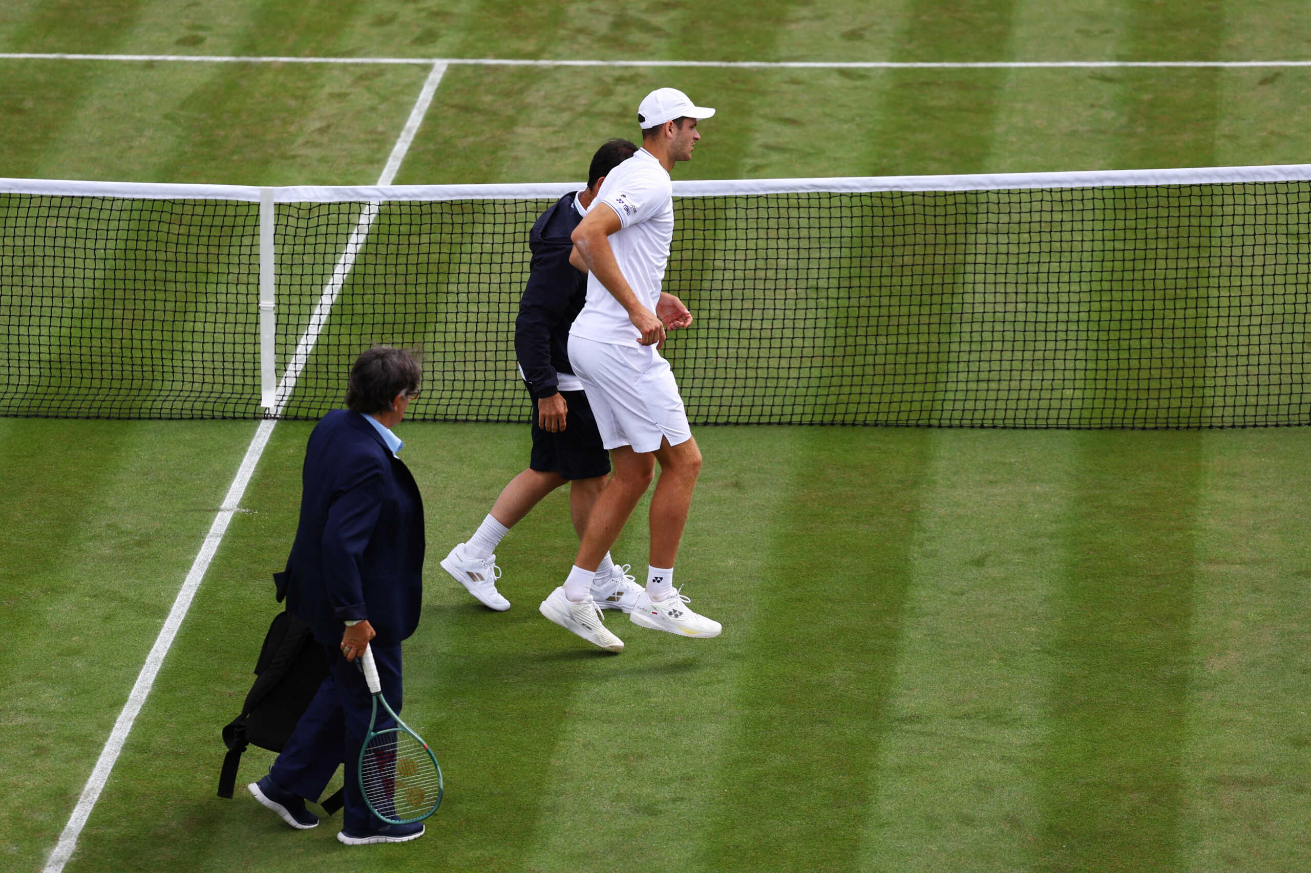 Tennis - Wimbledon - All England Lawn Tennis and Croquet Club, London, Britain - July 4, 2024 Poland's Hubert Hurkacz walks off the court after sustaining an injury during his second round match against France's Arthur Fils REUTERS