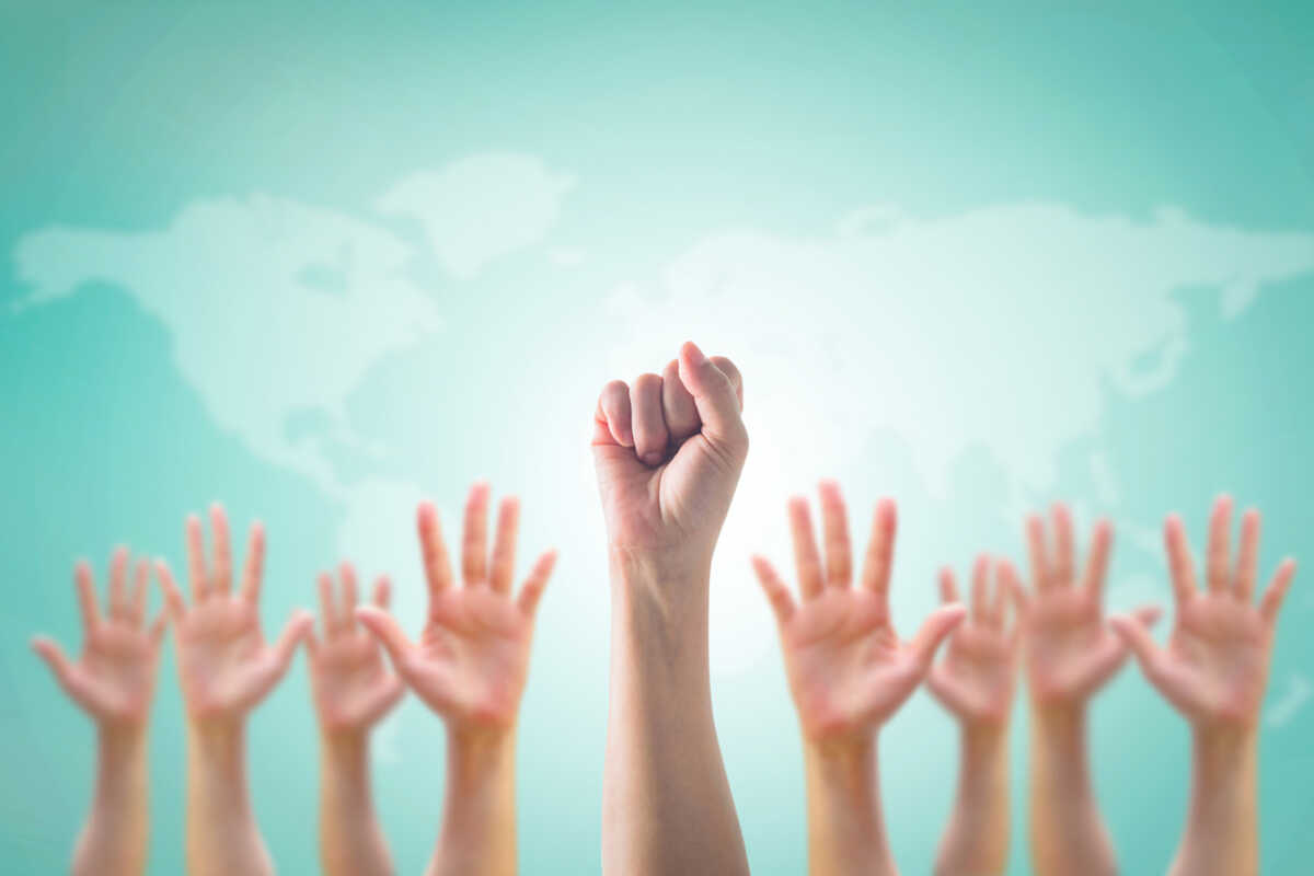 Empowering women power, human rights and labor day concept with strong fist hands on world map