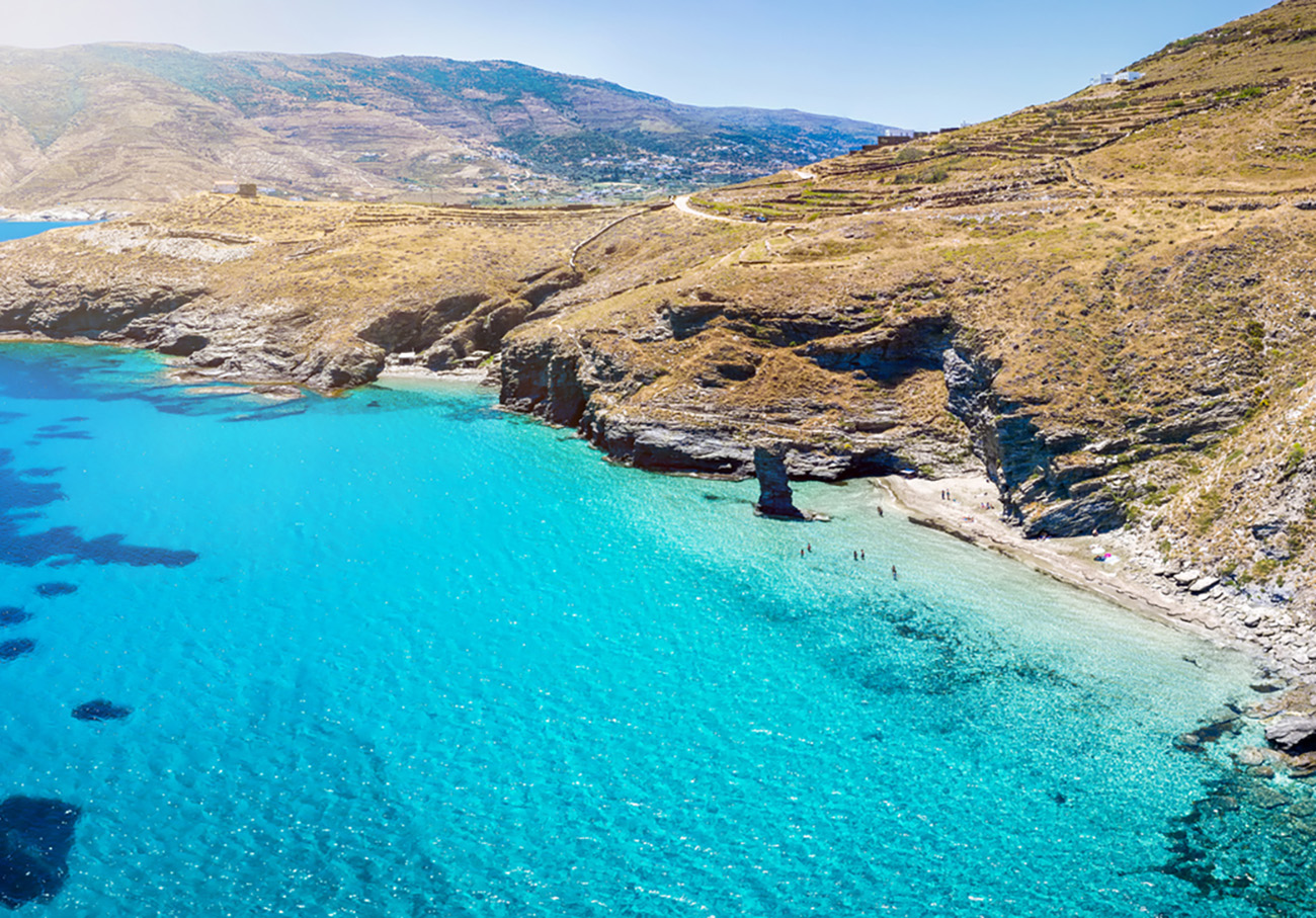 The popular beach Tis Grias to Pidima at the Greek island of Andros with sparkling, turquoise sea and unique rock formations