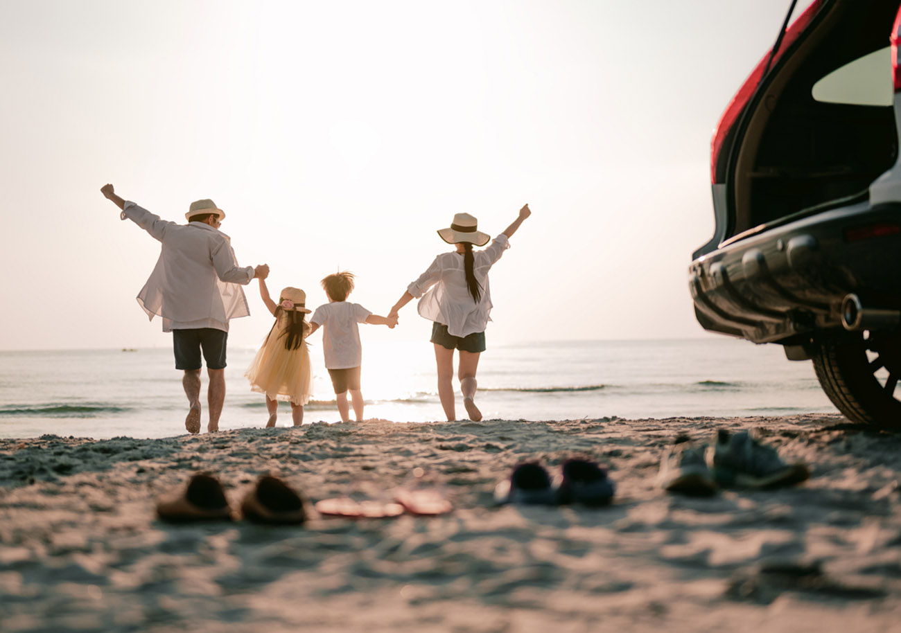 Family vacation holiday, Happy family running on the beach in the sunset. Back view of a happy family on a tropical beach and a car on the side.