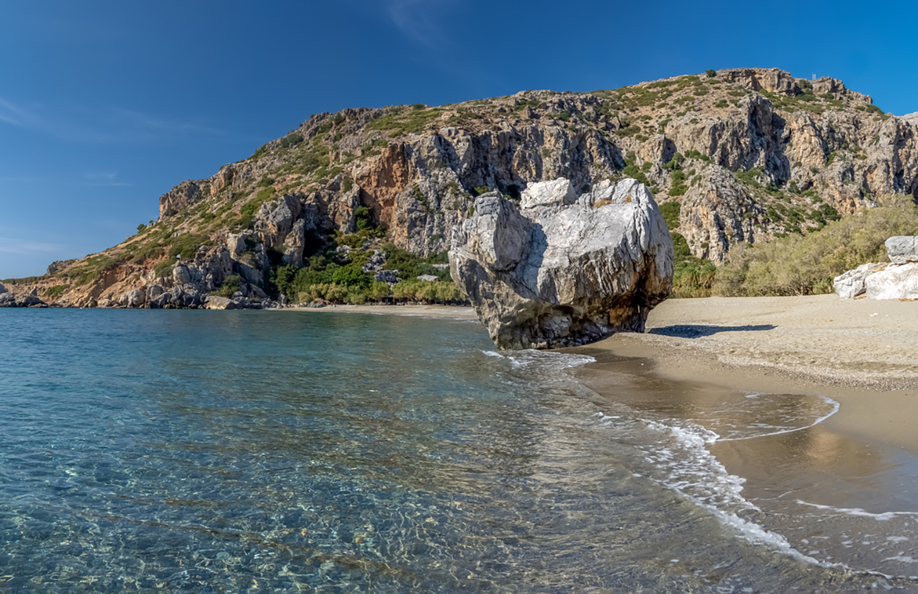 Stunning Preveli Beach, a secluded white sand beach surrounded by palm groves at the end of a gorge where the Megas river encounters the Libyan sea, Crete, Greece