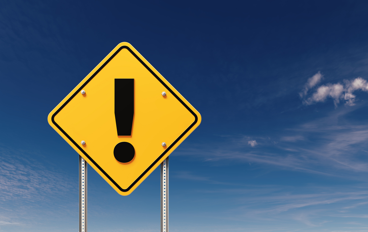Exclamation point written yellow off road traffic sign  before blue sky. Horizontal composition with copy space.