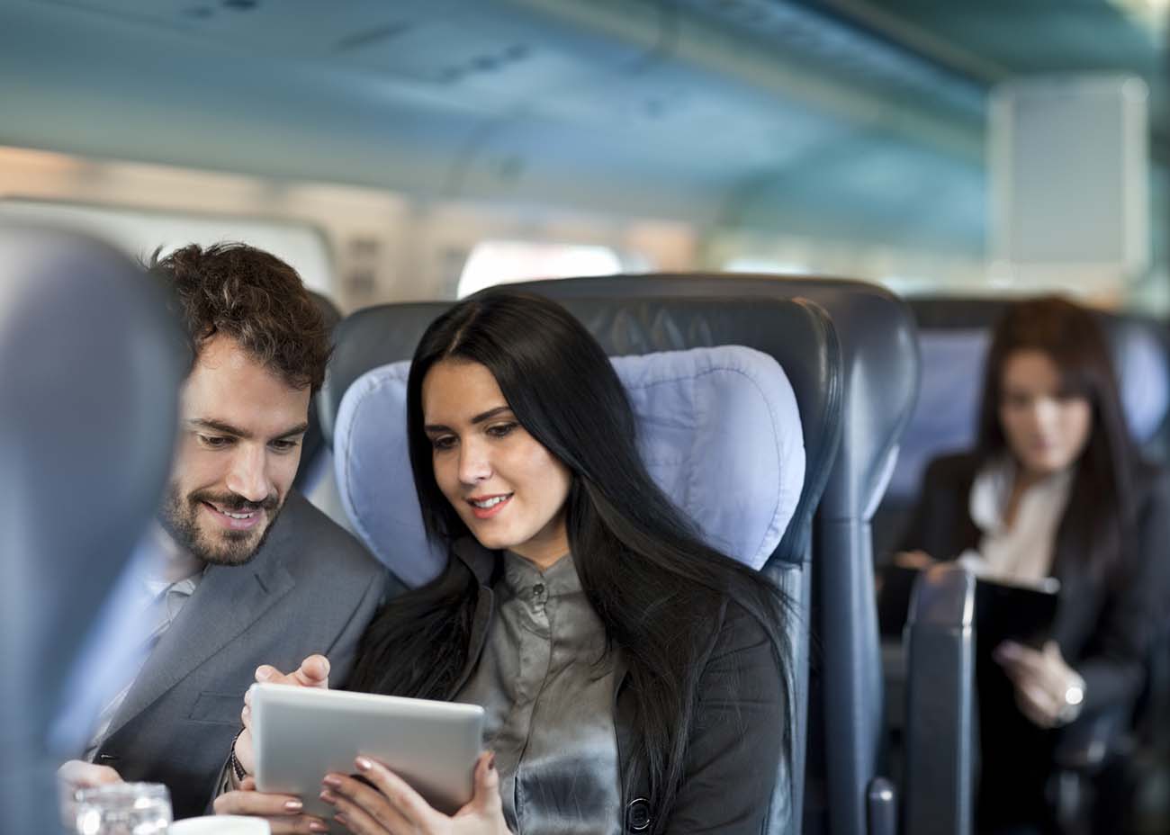 Business travel by train. Business people during a train journey, working. Communicateing  with mobile phones and digital tablet  and  transmitted content  over the Internet.