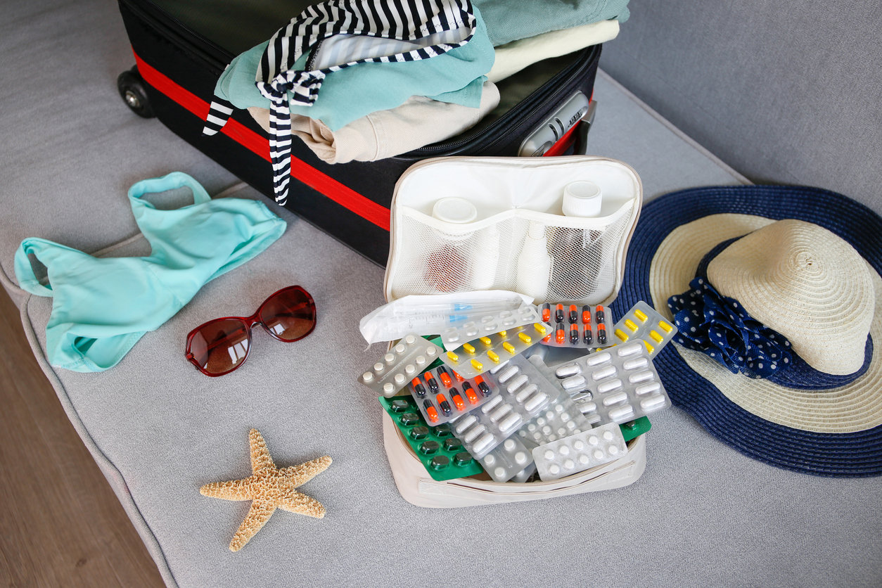 Summer beach accessories for your sea holiday and pills. Concept of medication required in journey.