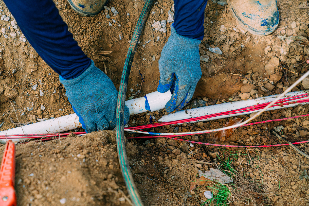 Irrigation Landscaping Worker Installing PVC Pipe for a Sprinkler System in New Construction in the Midwest, Southern USA