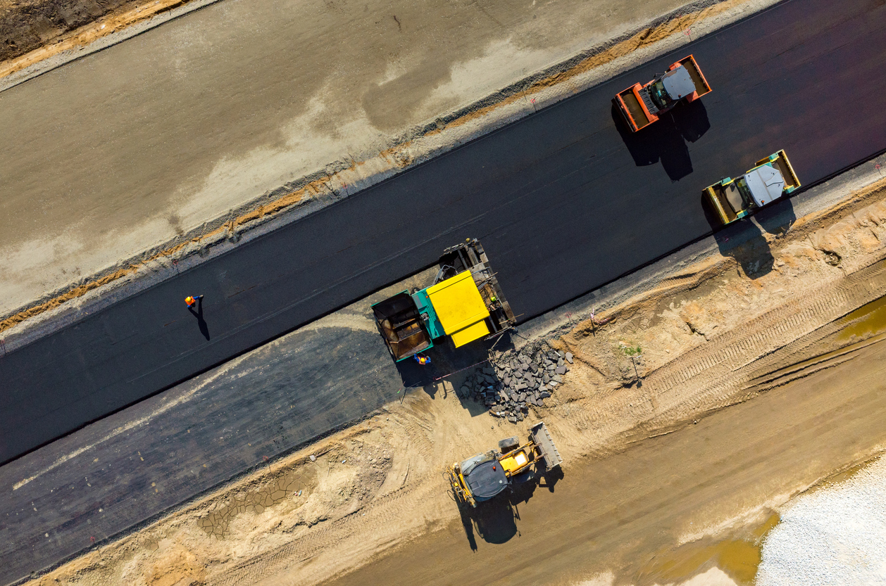 Aerial view on the road rollers working on the new road construction site