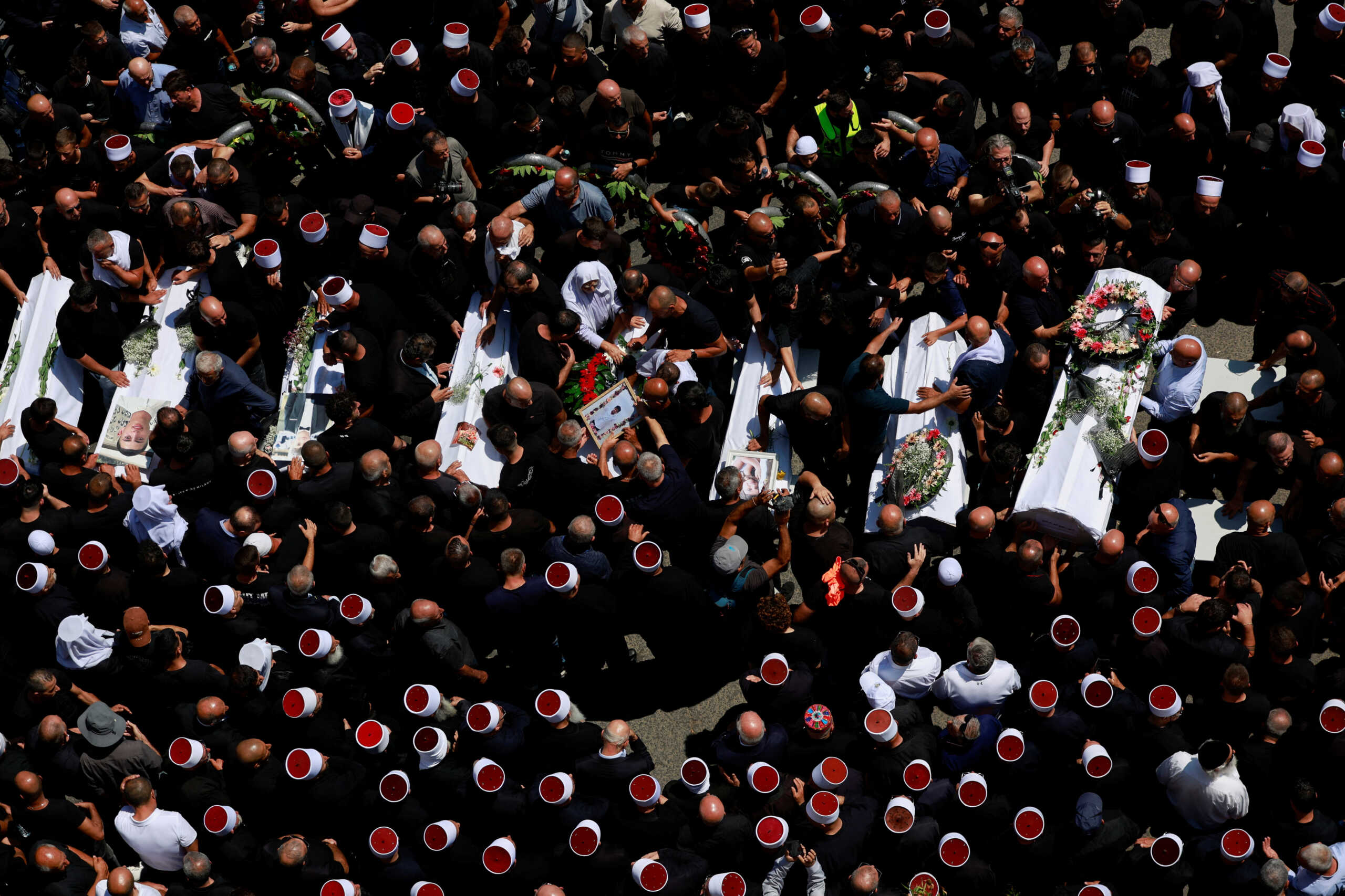 People gather during the funeral of children who were killed at a soccer pitch by a rocket fired from Lebanon, in Majdal Shams, a Druze village in the Israeli-occupied Golan Heights, July 28, 2024. REUTERS