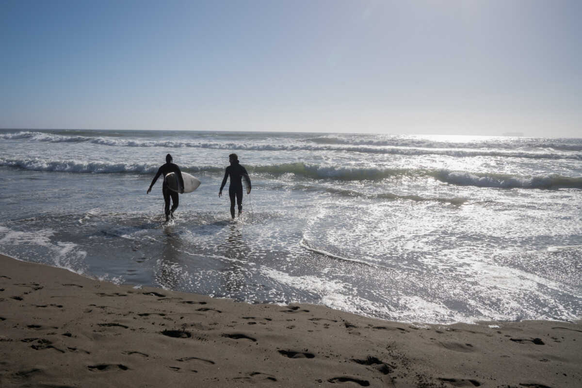 Local Residents walk into the water to surf at Ocean Beach during a heat wave as temperatures climbed to over 80 Fahrenheit (26.7 degrees Celsius), in San Francisco, California, U.S., July 2, 2024. REUTERS