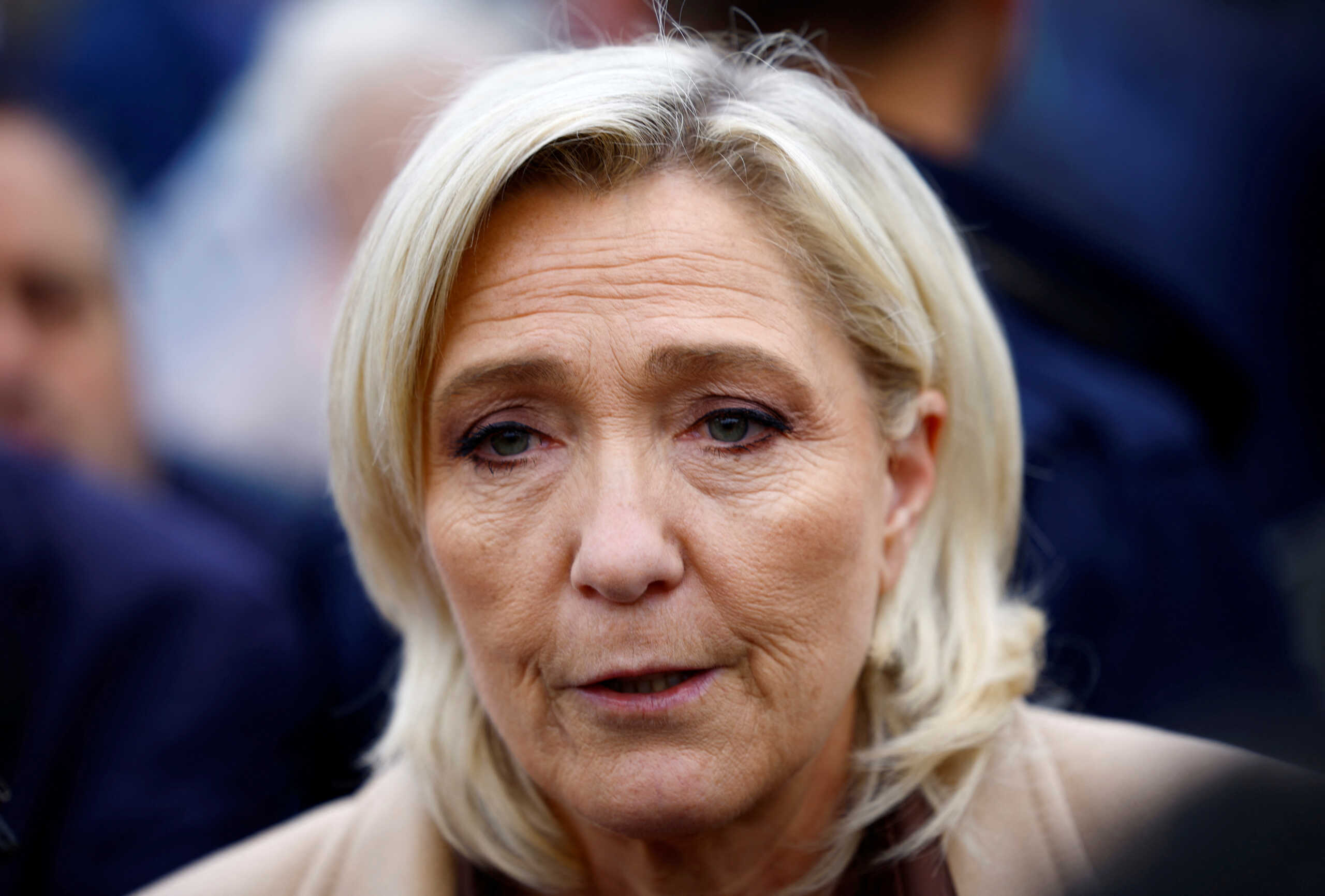 Marine Le Pen, French far-right leader and French far-right National Rally (Rassemblement National - RN) party candidate in the upcoming parliamentary elections, talks to journalists as she campaigns at a market in Henin-Beaumont, northern France, June 14, 2024. REUTERS