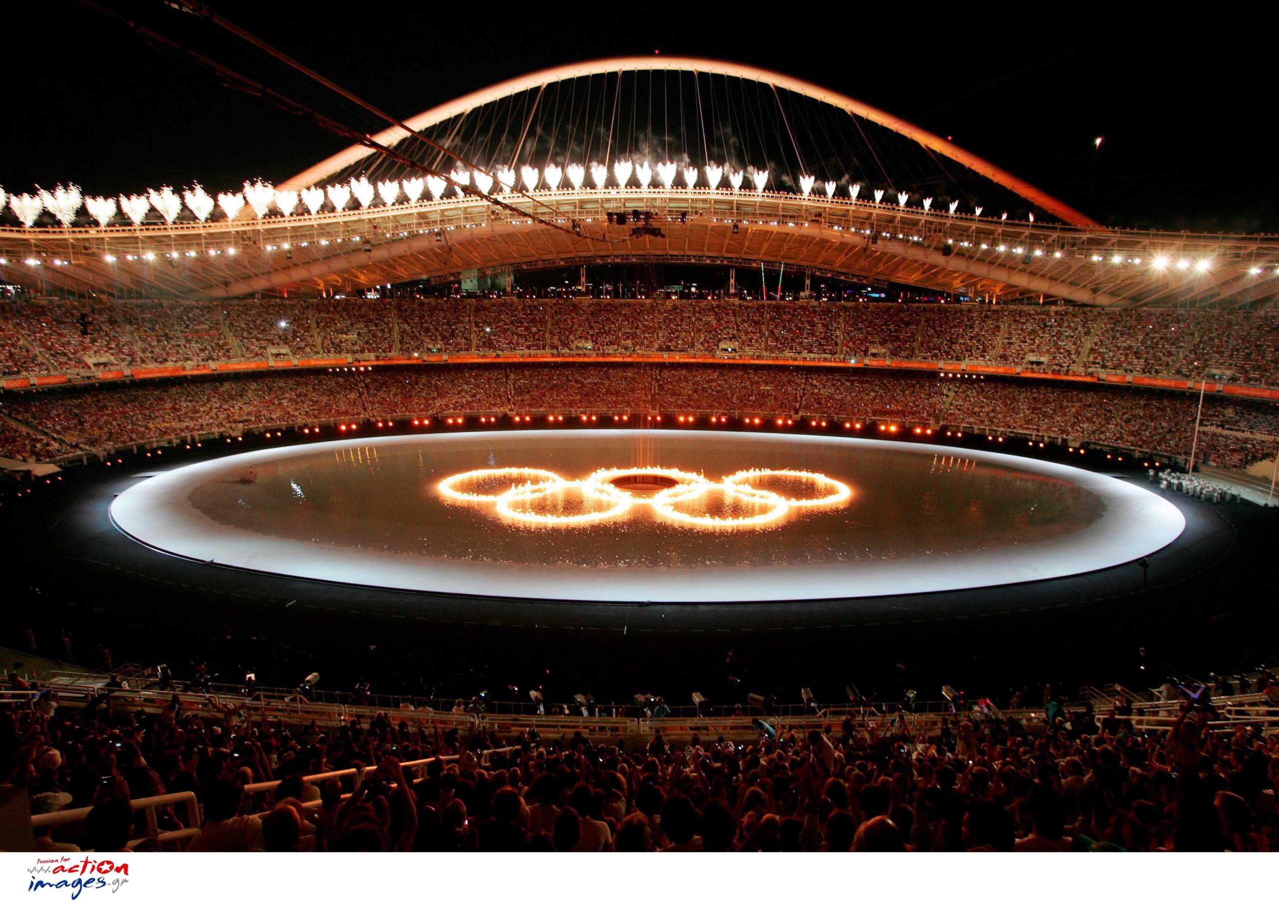 epa000249821 The Olympic Rings on fire are seen in the Olympic Stadium during the 2004 Athens Olympic Games opening ceremony, Friday 13 August 2004. More than 10.800 athletes will compete in the Olympics.     epa