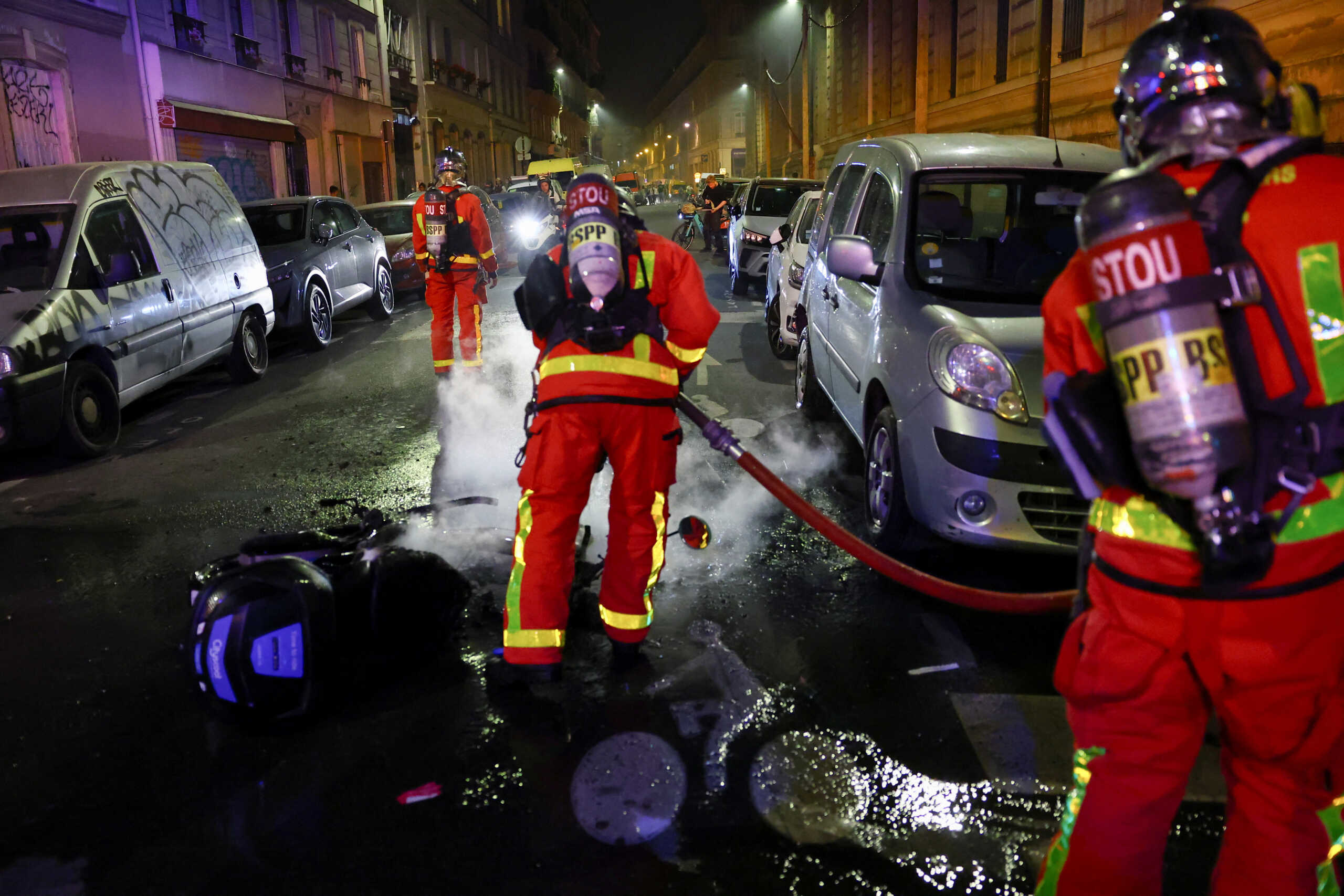 Firefighters douse a fire as protesters demonstrate against the French far-right Rassemblement National (National Rally - RN) party, following partial results in the first round of the early 2024 legislative elections, at the Place de la Republique in Paris, France, July 1, 2024. REUTERS