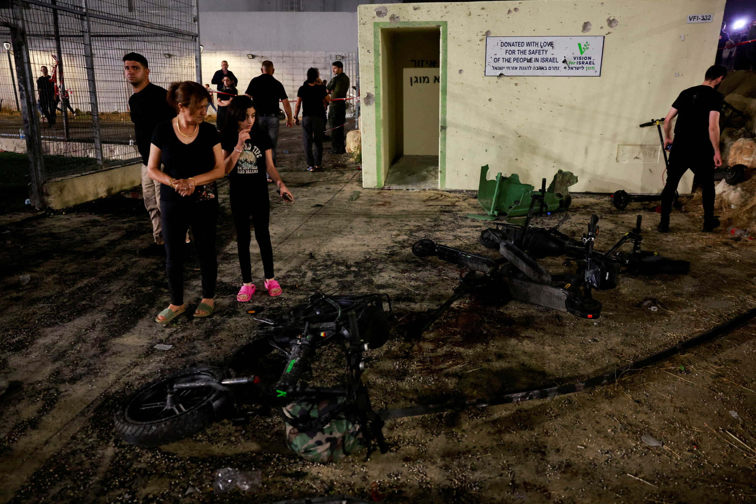FILE PHOTO: People look at the damage after rockets were launched across Lebanon's border with Israel which, according to Israel's ambulance services killed people, at a soccer pitch in Majdal Shams, a Druze village in the Israeli-occupied Golan Heights, July 27, 2024. REUTERS