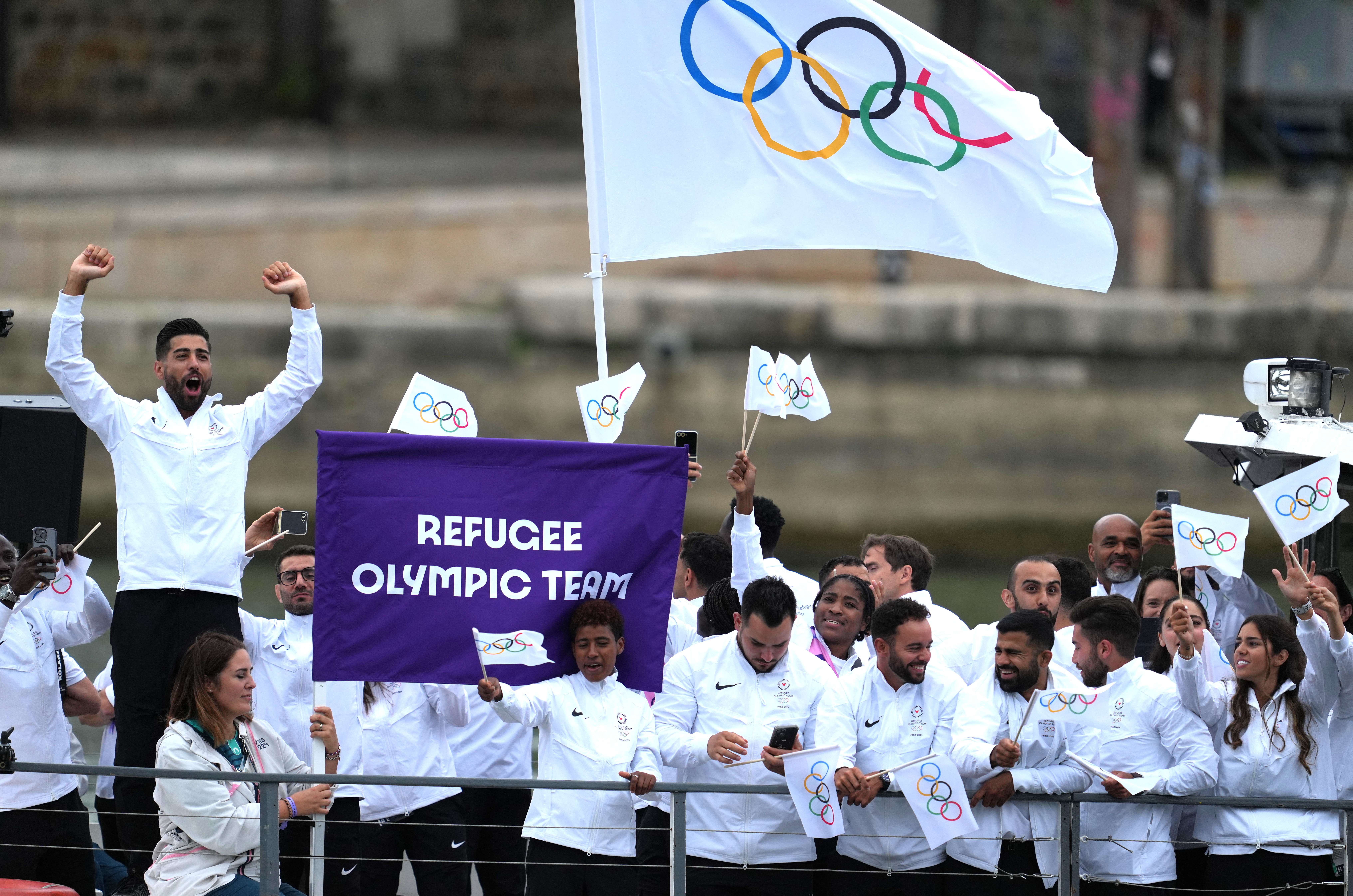 Paris 2024 Olympics - Opening Ceremony - Paris, France - July 26, 2024. Athletes of Refugee Olympic Team aboard a boat in the floating parade on the river Seine during the opening ceremony REUTERS