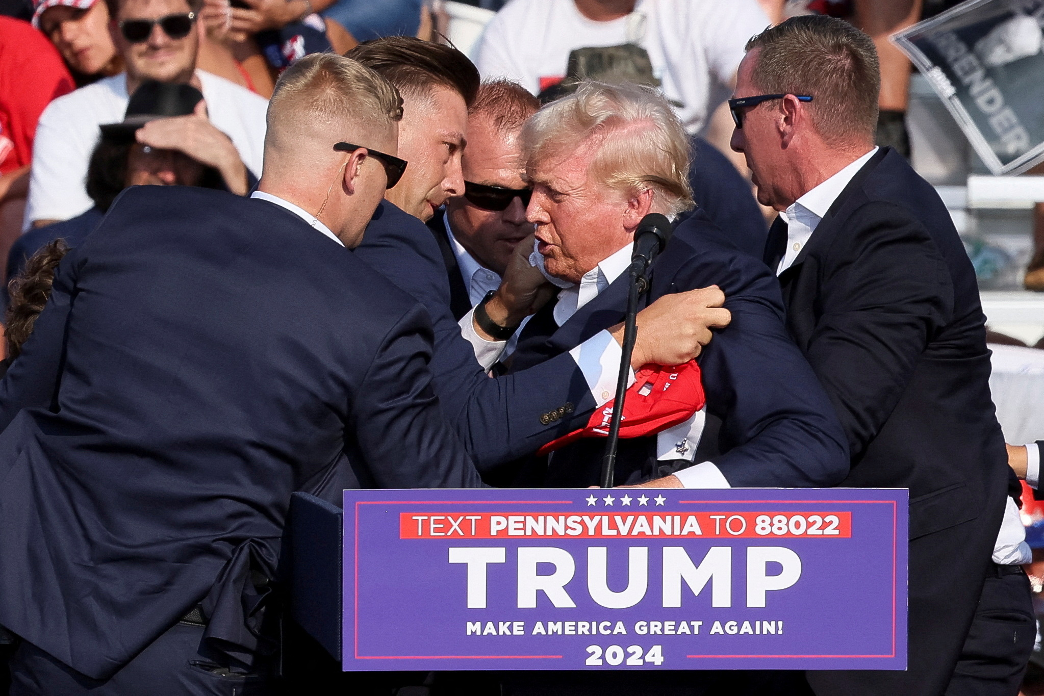 Republican presidential candidate and former U.S. President Donald Trump is assisted by guards during a campaign rally at the Butler Farm Show in Butler, Pennsylvania, U.S., July 13, 2024. REUTERS