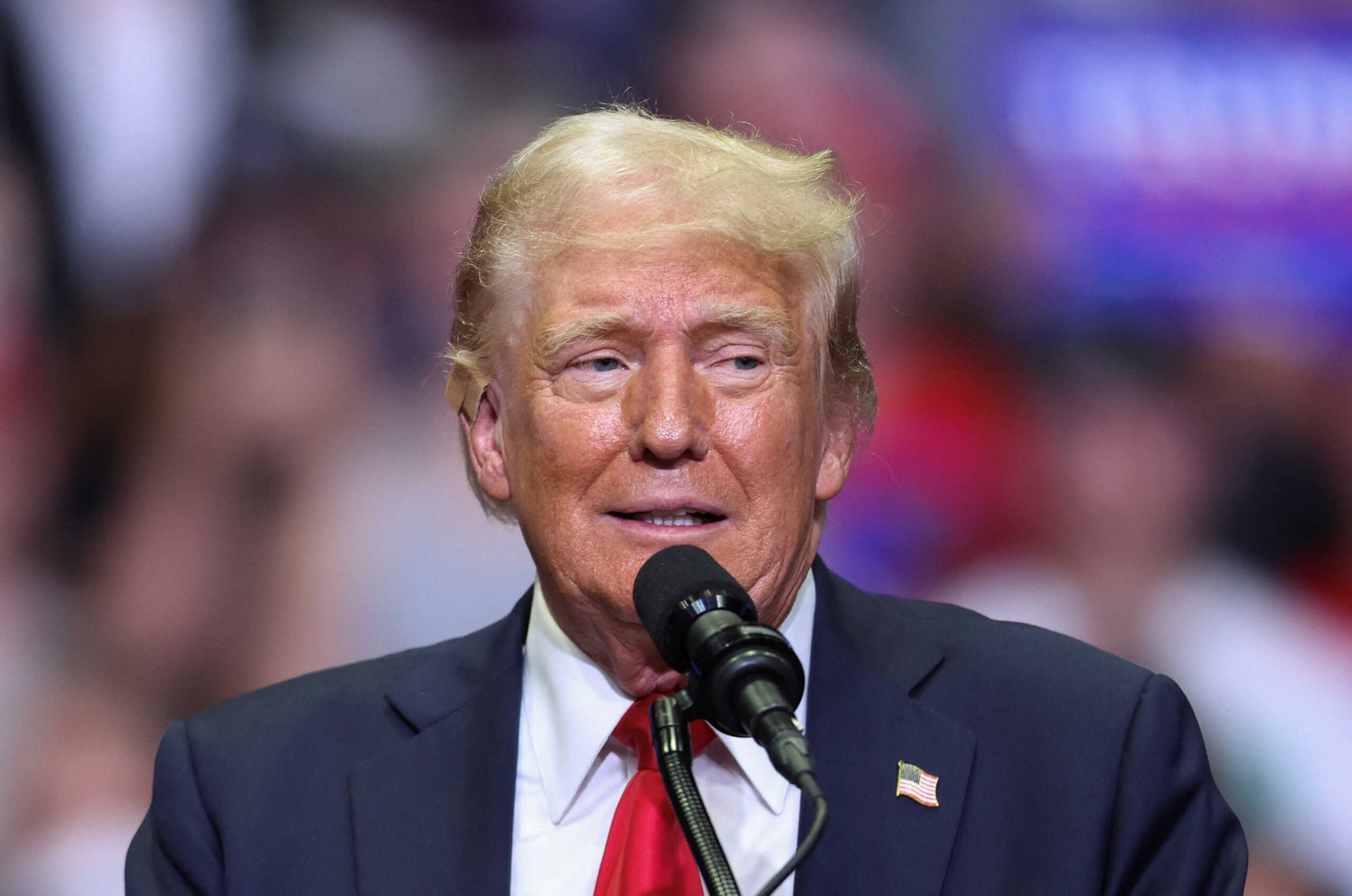 Republican presidential nominee and former U.S. President Donald Trump wears a flesh-colored bandage on his ear as he holds a campaign rally for the first time with his running mate, Republican vice presidential nominee U.S. Senator J.D. Vance (R-OH) in Grand Rapids, Michigan, U.S. July 20, 2024. REUTERS