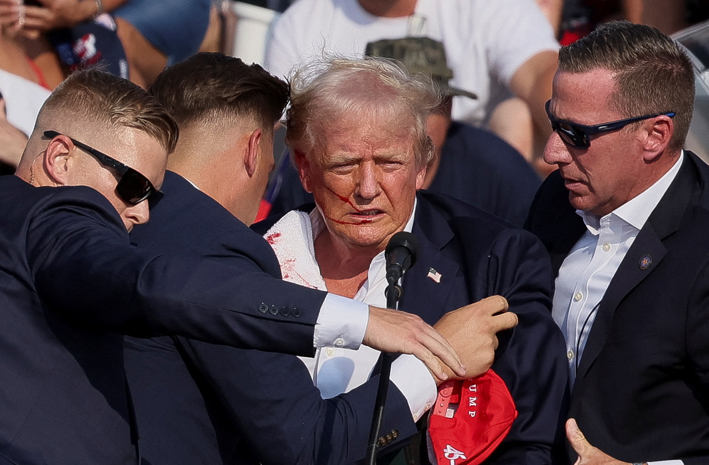 Republican presidential candidate and former U.S. President Donald Trump is assisted by U.S. Secret Service personnel after gunfire rang out during a campaign rally at the Butler Farm Show in Butler, Pennsylvania, U.S., July 13, 2024. REUTERS