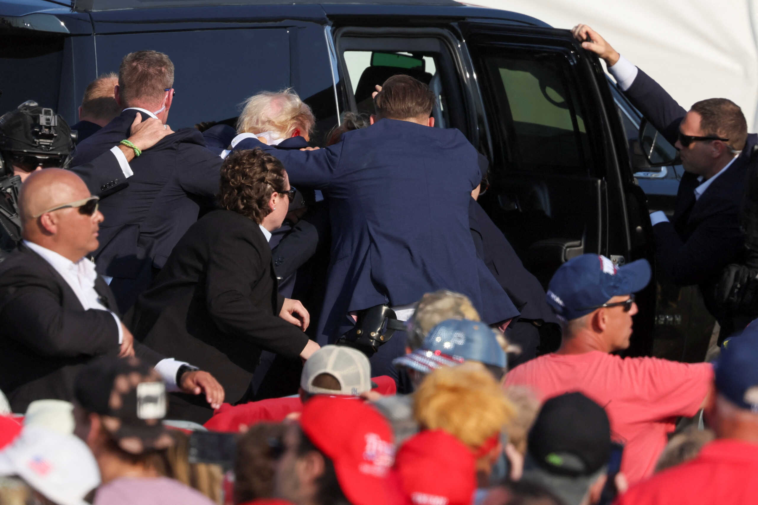Republican presidential candidate and former U.S. President Donald Trump gets into a vehicle with the assistance of U.S. Secret Service personnel after he was shot in the right ear during a campaign rally at the Butler Farm Show in Butler, Pennsylvania, U.S., July 13, 2024. REUTERS