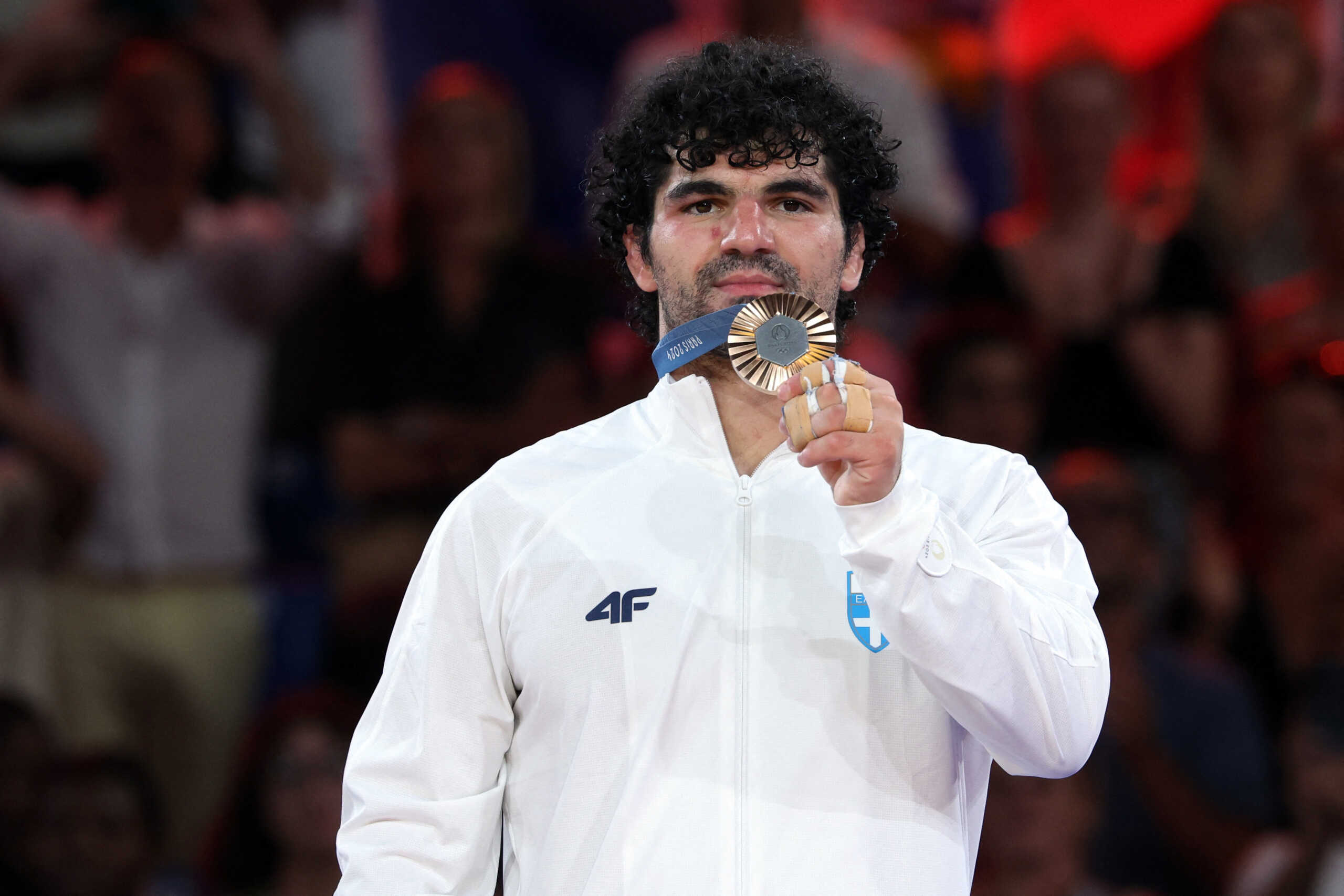 Paris 2024 Olympics - Judo - Men -90 kg Victory Ceremony - Champ-de-Mars Arena, Paris, France - July 31, 2024.  Bronze medallist Theodoros Tselidis of Greece celebrates on the podium. REUTERS