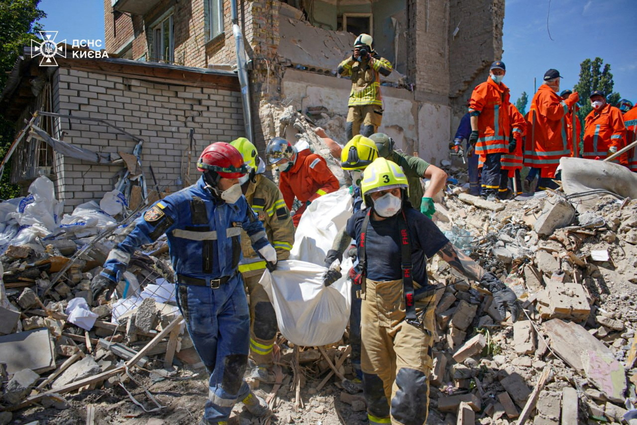 Rescuers carry the body of a person found under debris at the site where an apartment building was hit by a Russian missile strike, amid Russia's attack on Ukraine, in Kyiv, Ukraine July 9, 2024. Press service of the State Emergency Service of Ukraine