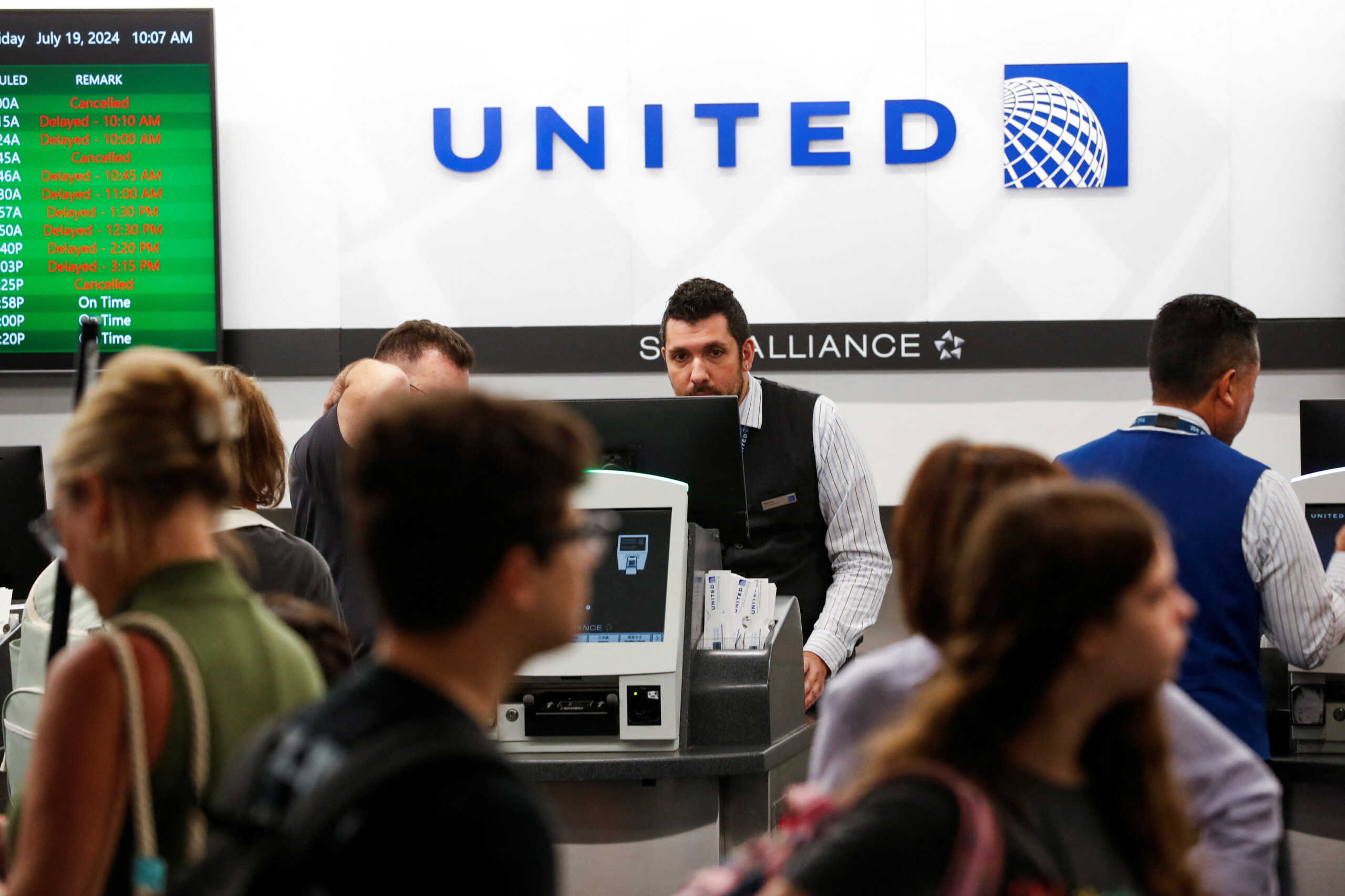 Airline passengers wait in line to check in at the United ticket counters after airlines grounded flights due to a worldwide tech outage caused by an update to CrowdStrike's "Falcon Sensor" software which crashed Microsoft Windows systems, at Tampa International Airport in Tampa, Florida, U.S., July 19, 2024. REUTERS