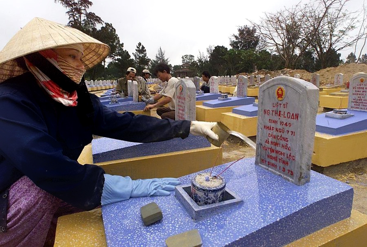 QTR02 - 20000323 - TRUONG SON CEMETERY, VIET NAM : Workers clean and repaint gravestone at Truong Son cemetery, the country's largest military cemetery in central Quang Tri province 23 March 2000. More than 10,000 Vietnamese communist army's soldiers killed during the Vietnam War are buried in the cemetery.  Graves at the cemetery are being repainted as part of the preparations for the celebrations marking the 25th anniversary of the end of the war which began this month. (ELECTRONIC IMAGE)  
EPA PHOTO AFP