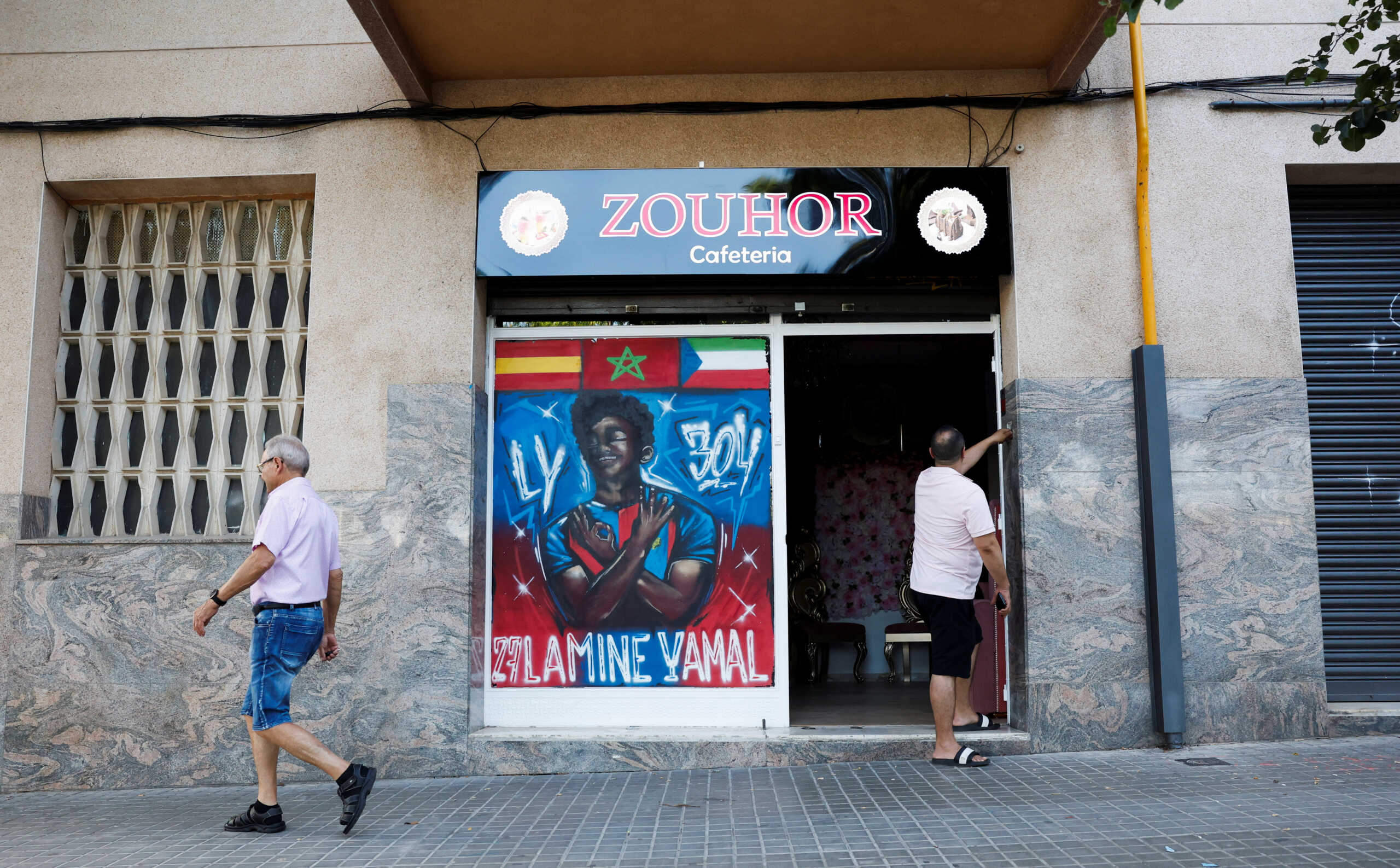 A person walks past the painting of soccer player Lamine Yamal at a coffee shop in the Rocafonda neighbourhood in Mataro, north of Barcelona, Spain, July 11, 2024. REUTERS