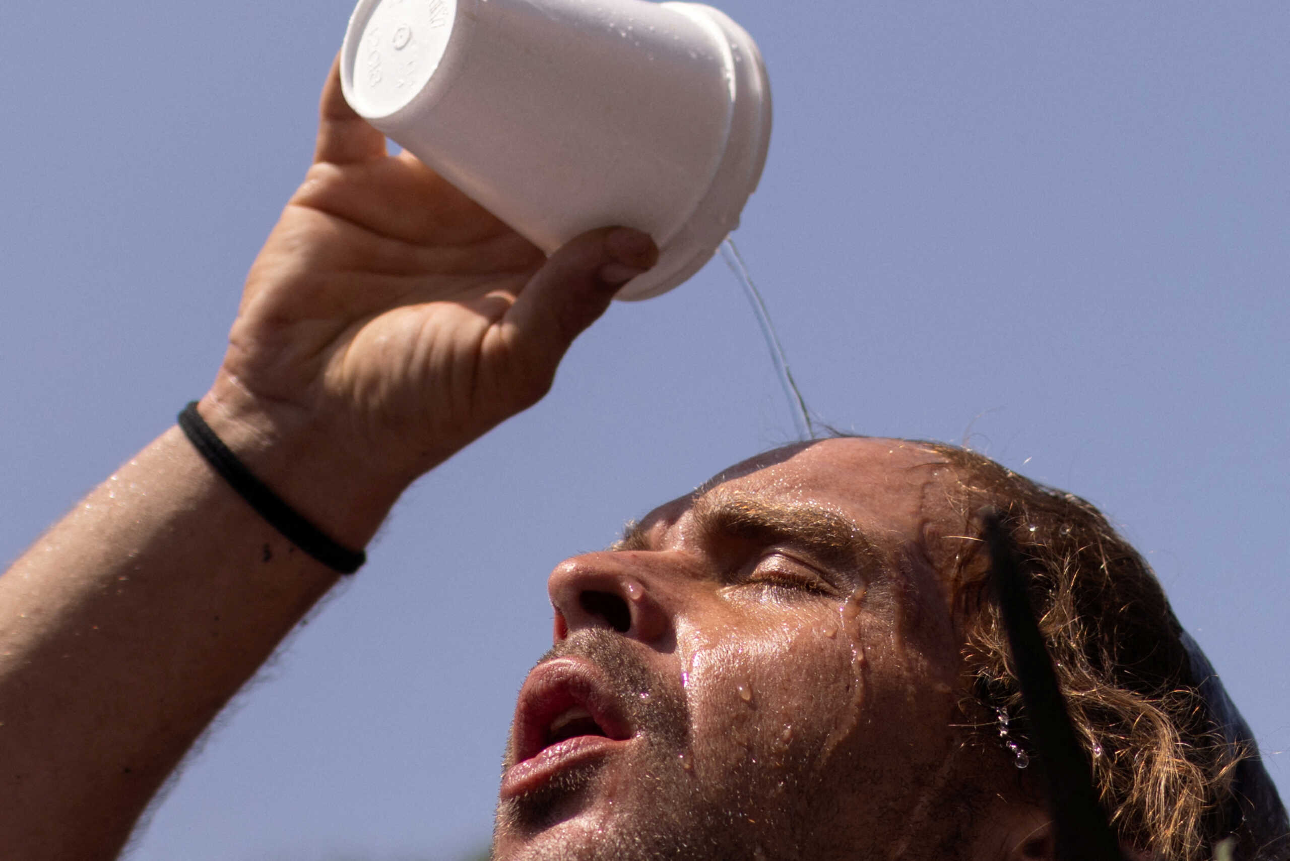 FILE PHOTO: Nico pours water atop his head outside the Emergency Aid Coalition during a heat wave in Houston, Texas, U.S., August 25, 2023.  REUTERS