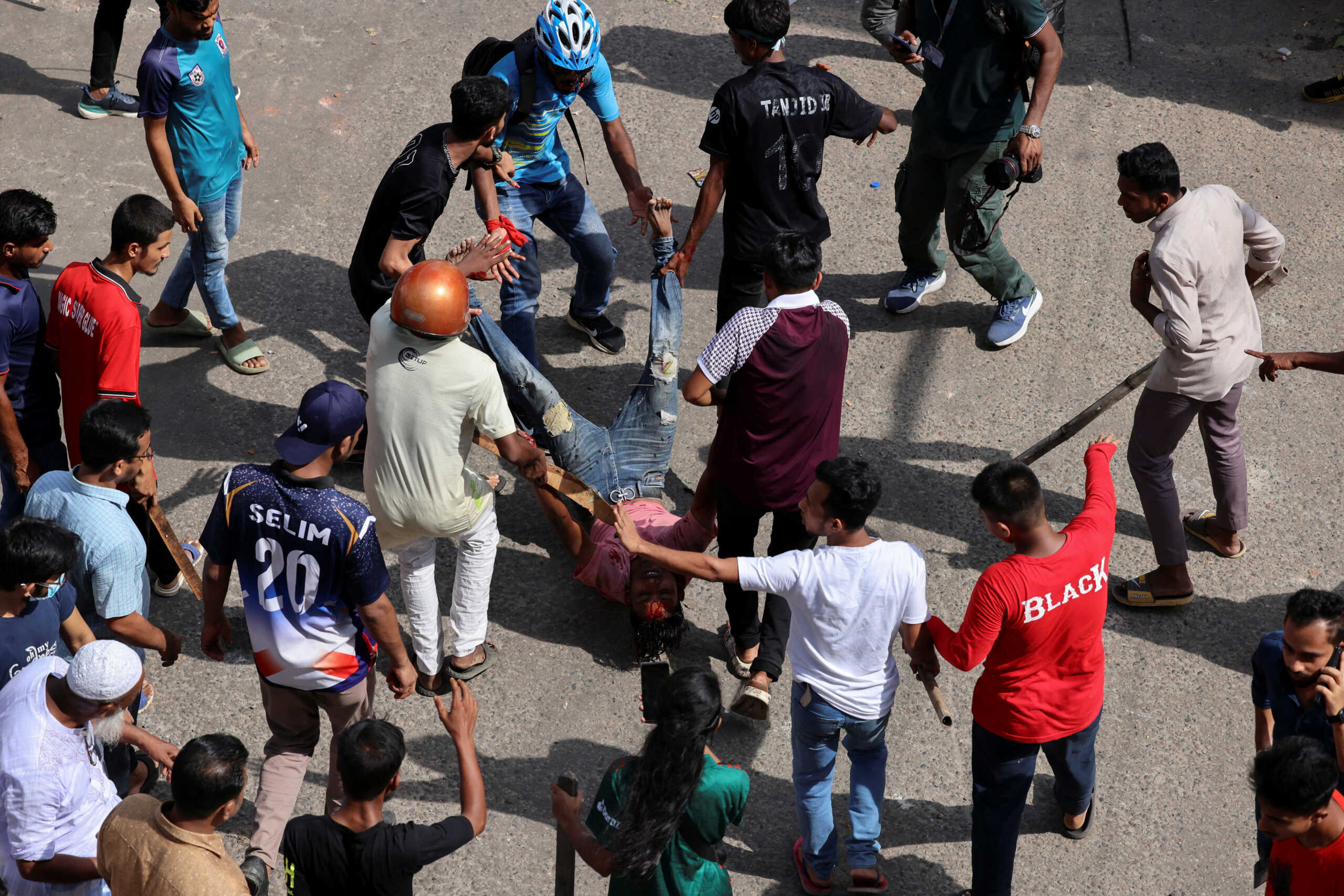 A man, who got injured during a clash between police, pro-government supporters and protesters, is taken in a safe place by fellow demonstrators, after anti-quota protesters were demanding the stepping down of the Bangladeshi Prime Minister Sheikh Hasina at the Bangla Motor area, in Dhaka, Bangladesh, August 4, 2024. REUTERS