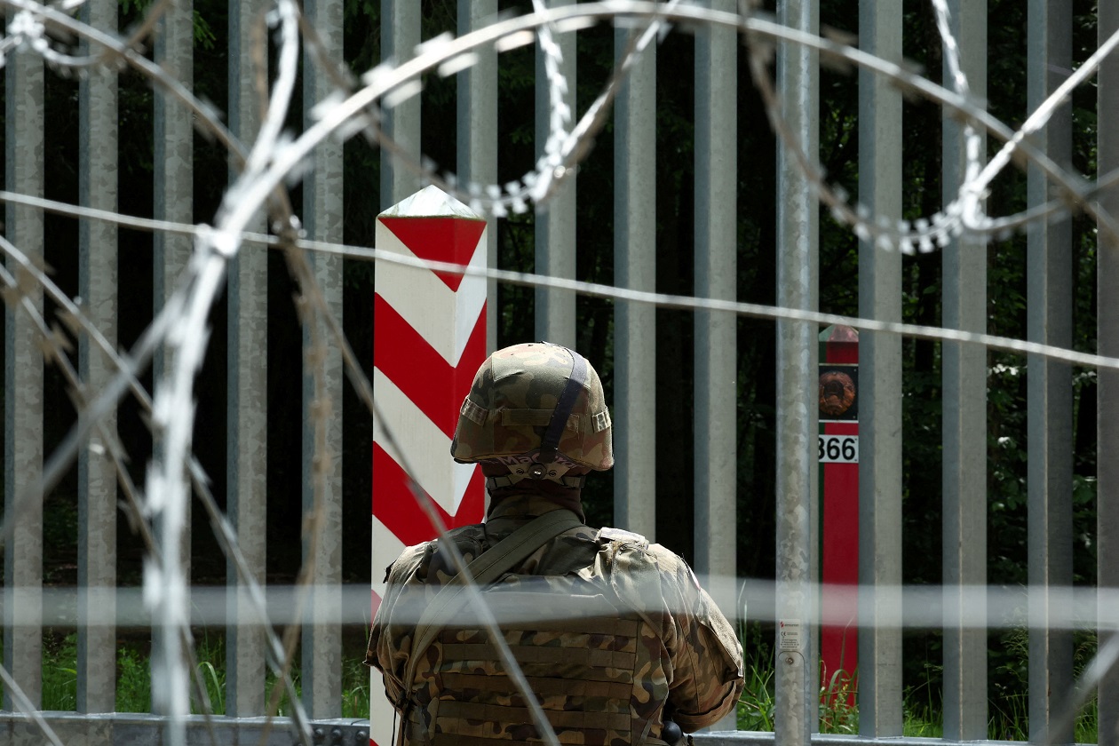 FILE PHOTO: A soldier stands guard near the fence on the Belarusian-Polish border in the forest near Bialowieza, Poland, June 4, 2024. REUTERS
