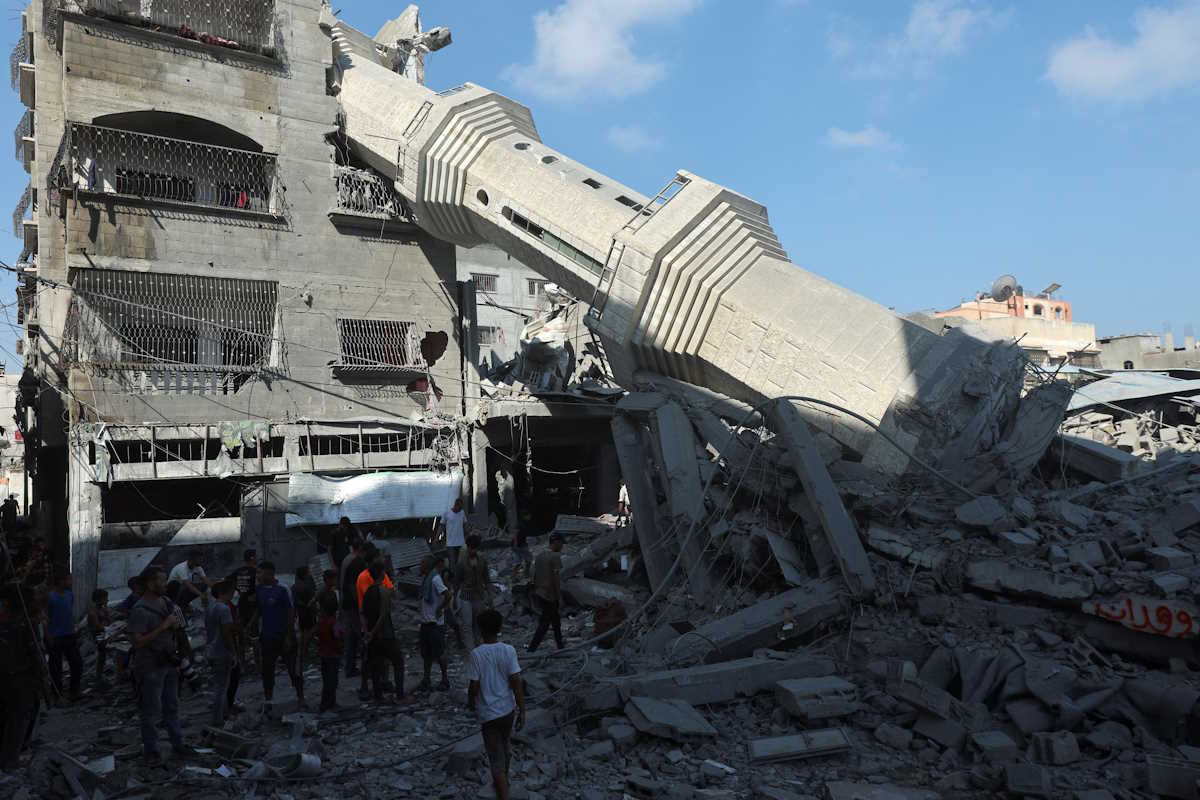 Palestinians inspect the damage as the collapsed minaret of Abdullah Azzam mosque leans against a house after the mosque was hit by an Israeli strike, amid the Israel-Hamas conflict, in Nuseirat refugee camp in the central Gaza Strip, July 17, 2024. REUTERS