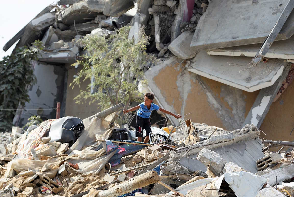 A boy gestures as he stands among rubble, after Israeli forces withdrew from the area, following a ground operation, amid the ongoing conflict between Israel and Hamas, in Khan Younis, in the southern Gaza Strip, August 30, 2024. REUTERS